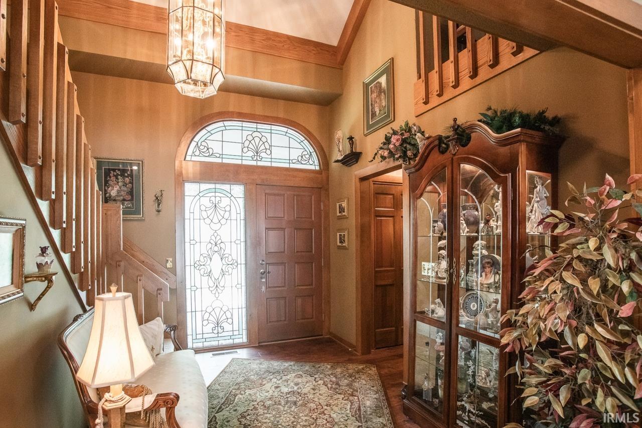 Gracious entry featuring a solid wood door with decorative leaded glass sidelights and arched transom