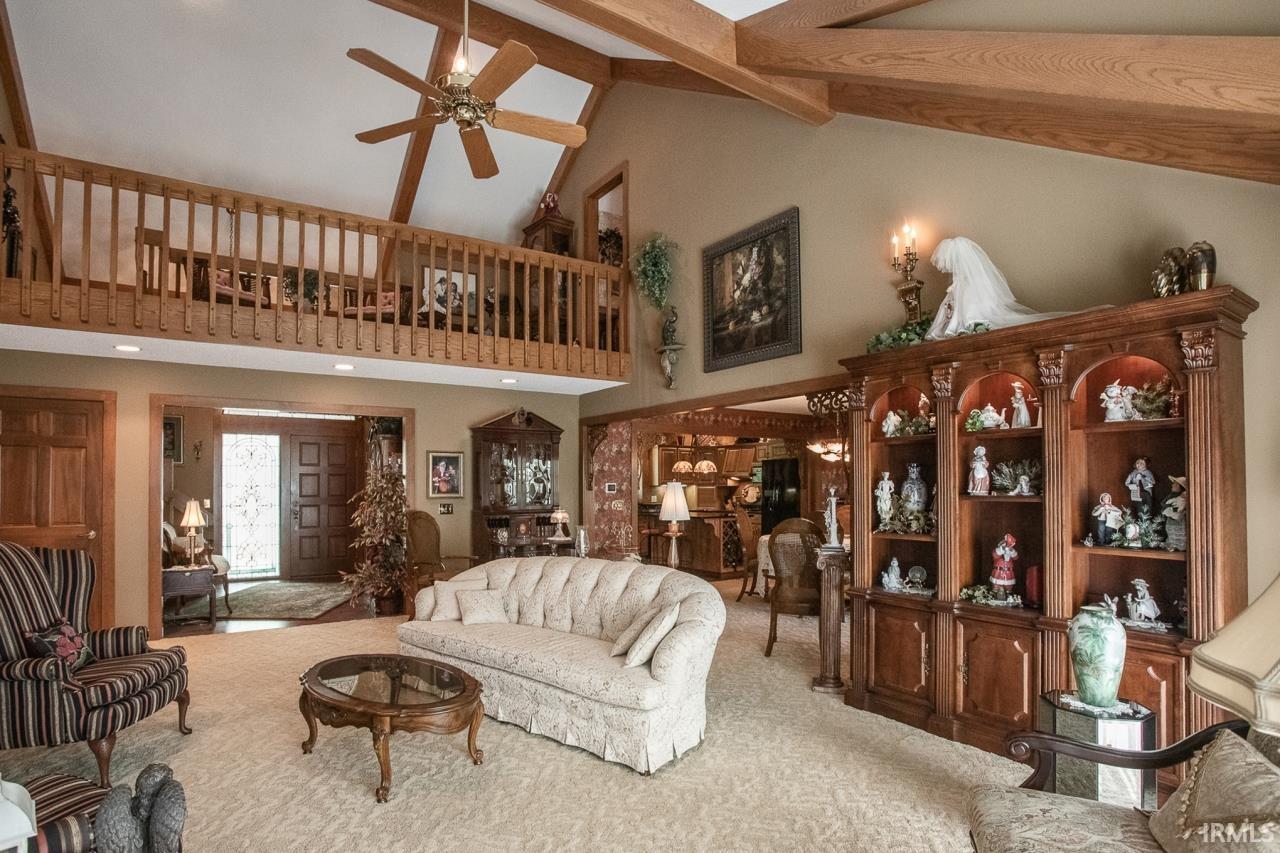 Vaulted ceiling with exposed wood beams and a ceiling fan