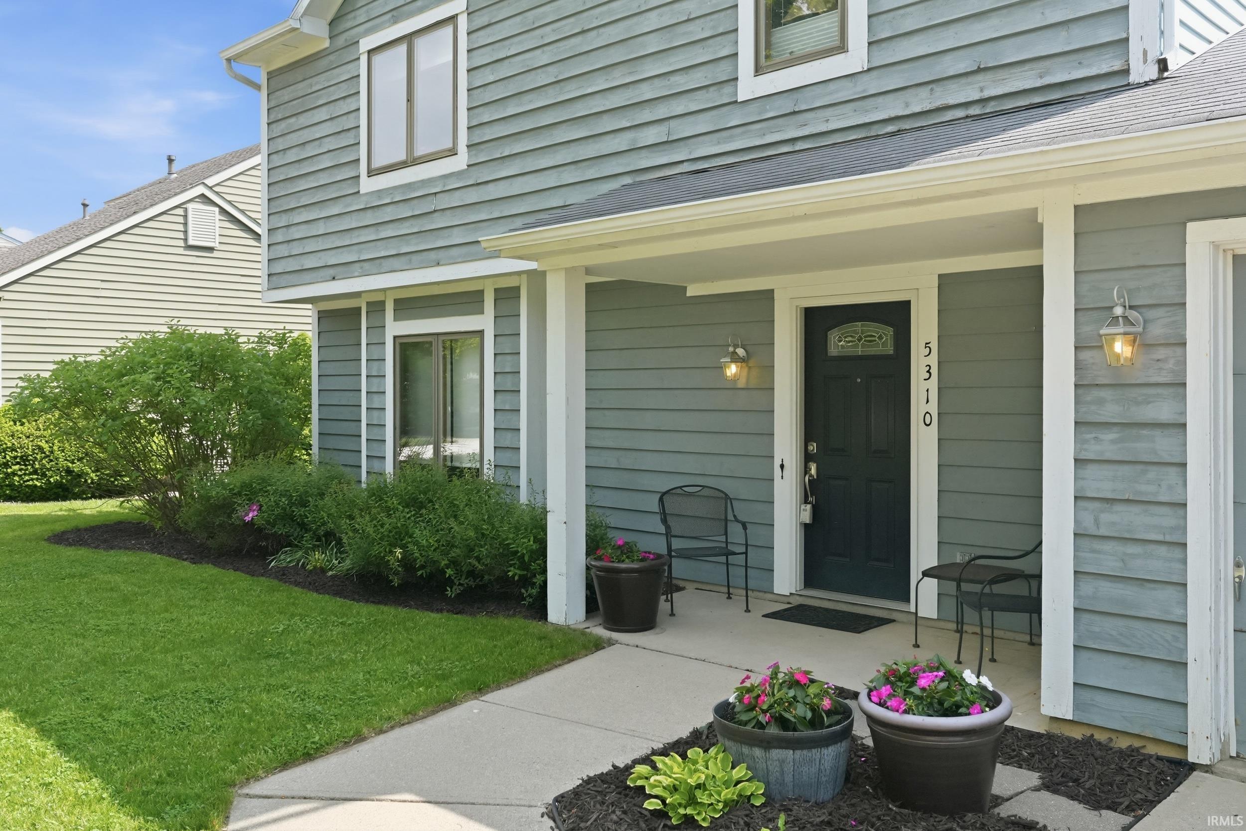 Exterior entry featuring horizontal siding, white trim, and an overhead portico