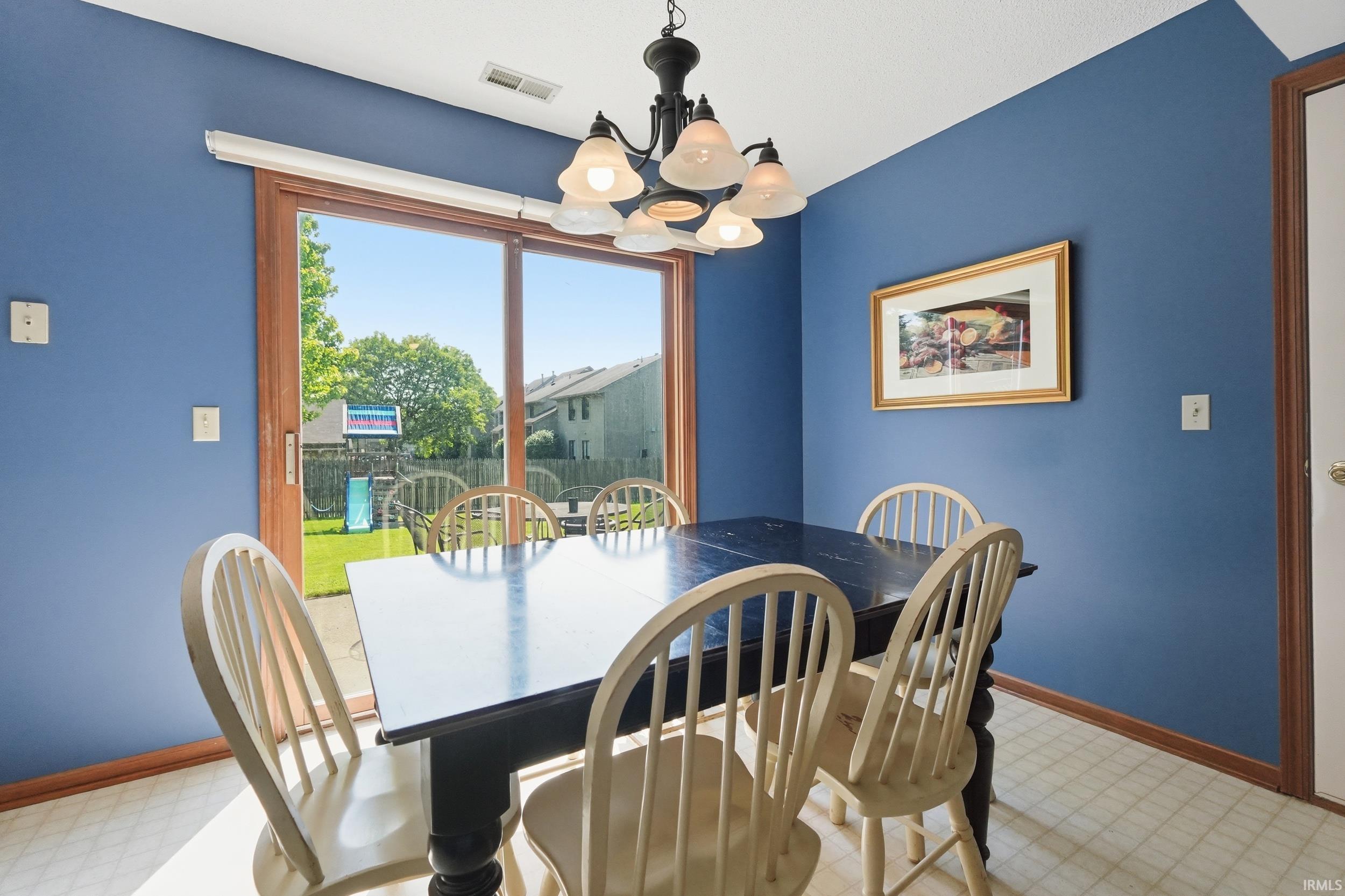 Dining area featuring a sliding glass door with wood trim, offering direct access to the backyard