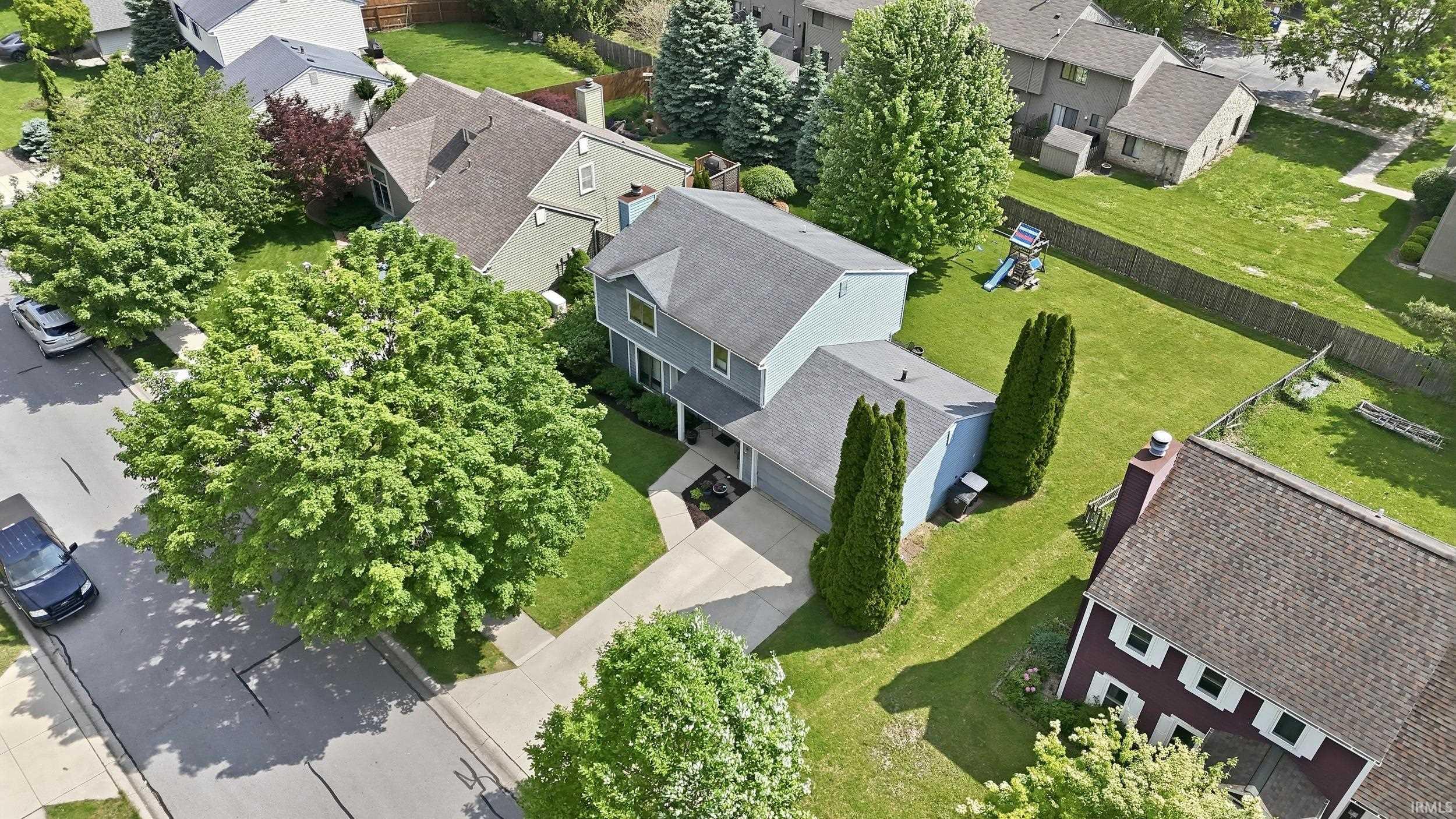 Two-story residence featuring a light blue exterior, attached two-car garage, and a concrete driveway