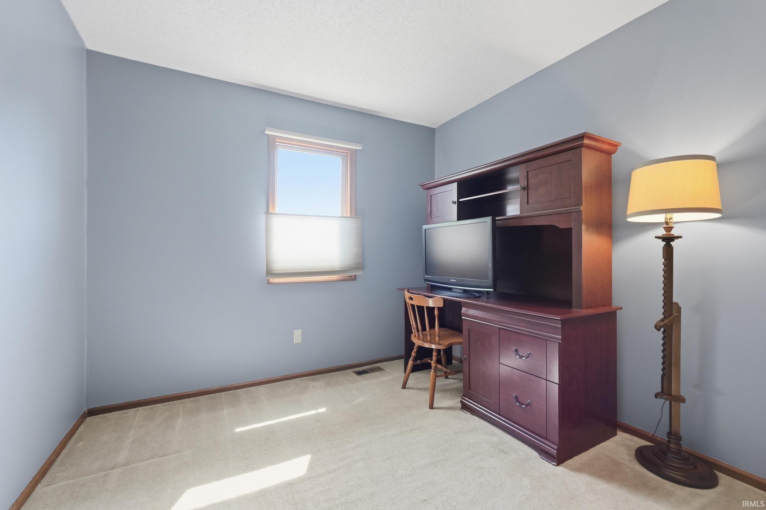Light blue walls complement the neutral carpet flooring and white ceiling