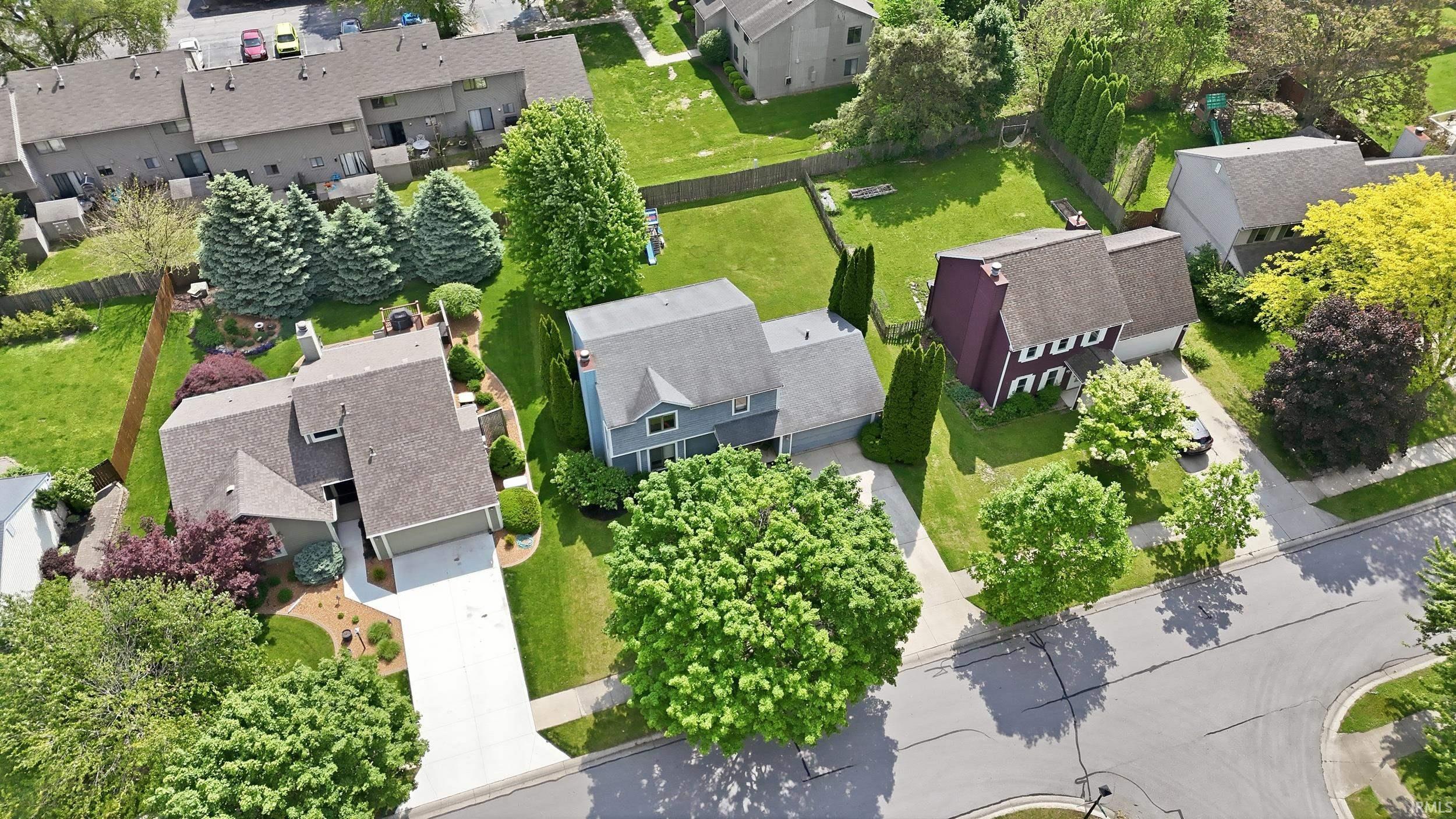Aerial view of a residential neighborhood featuring multiple single-family homes with pitched roofs and attached garages