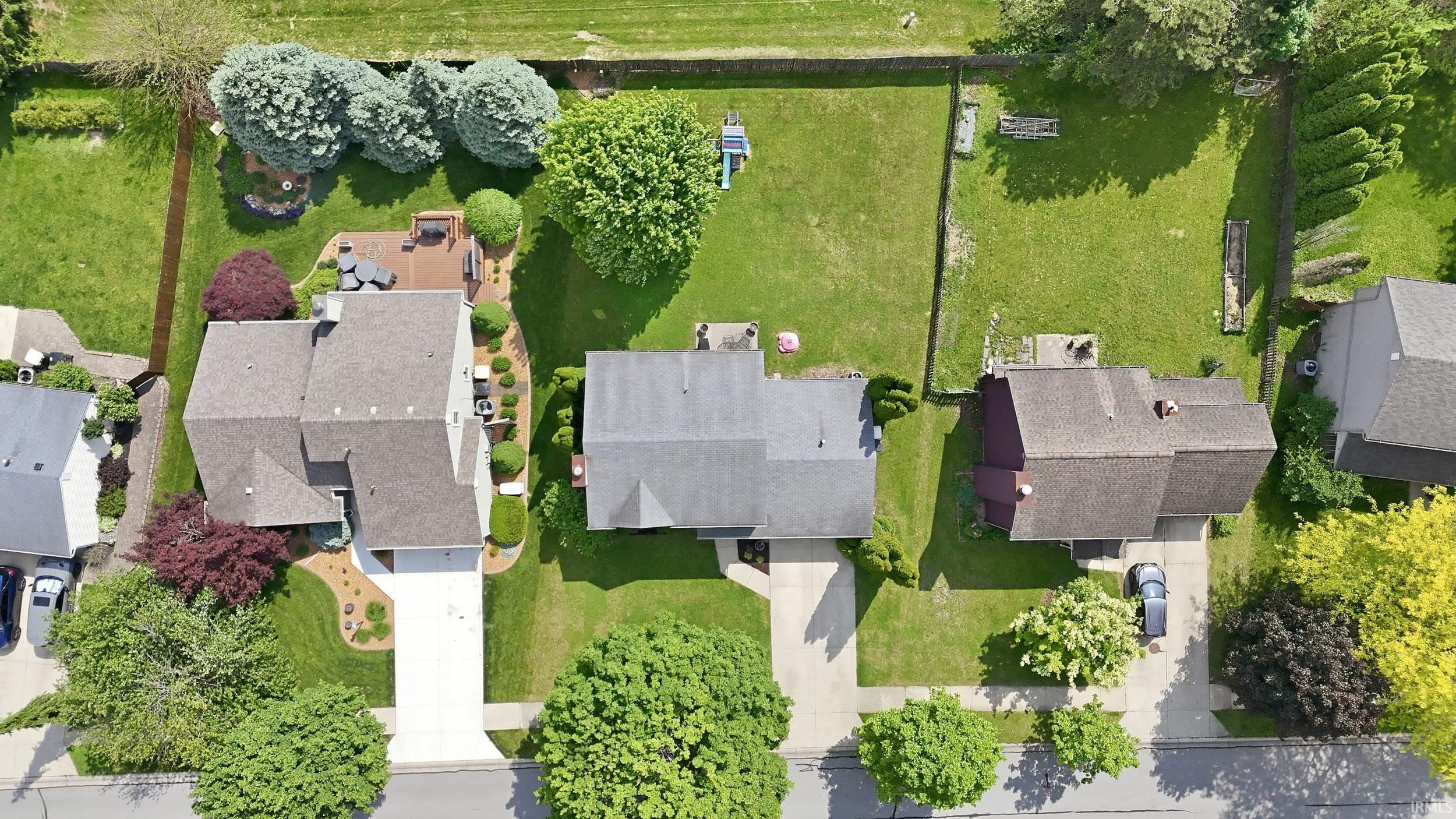 Spacious residential property featuring a large backyard, mature trees, and a multi-level deck