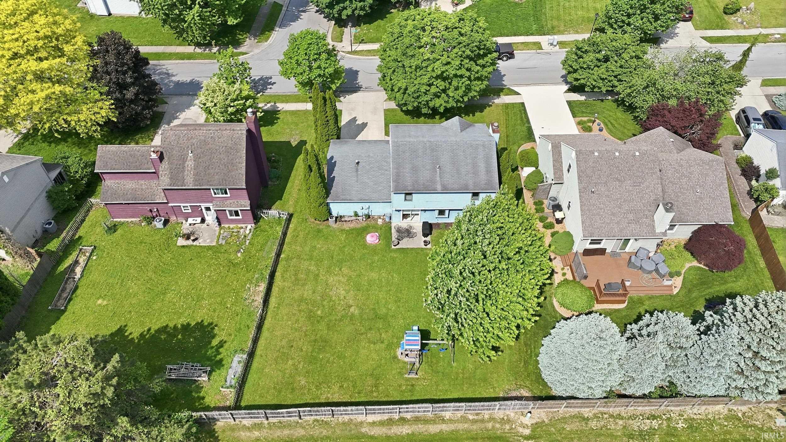 Expansive green spaces define this property, featuring a generous backyard with established trees