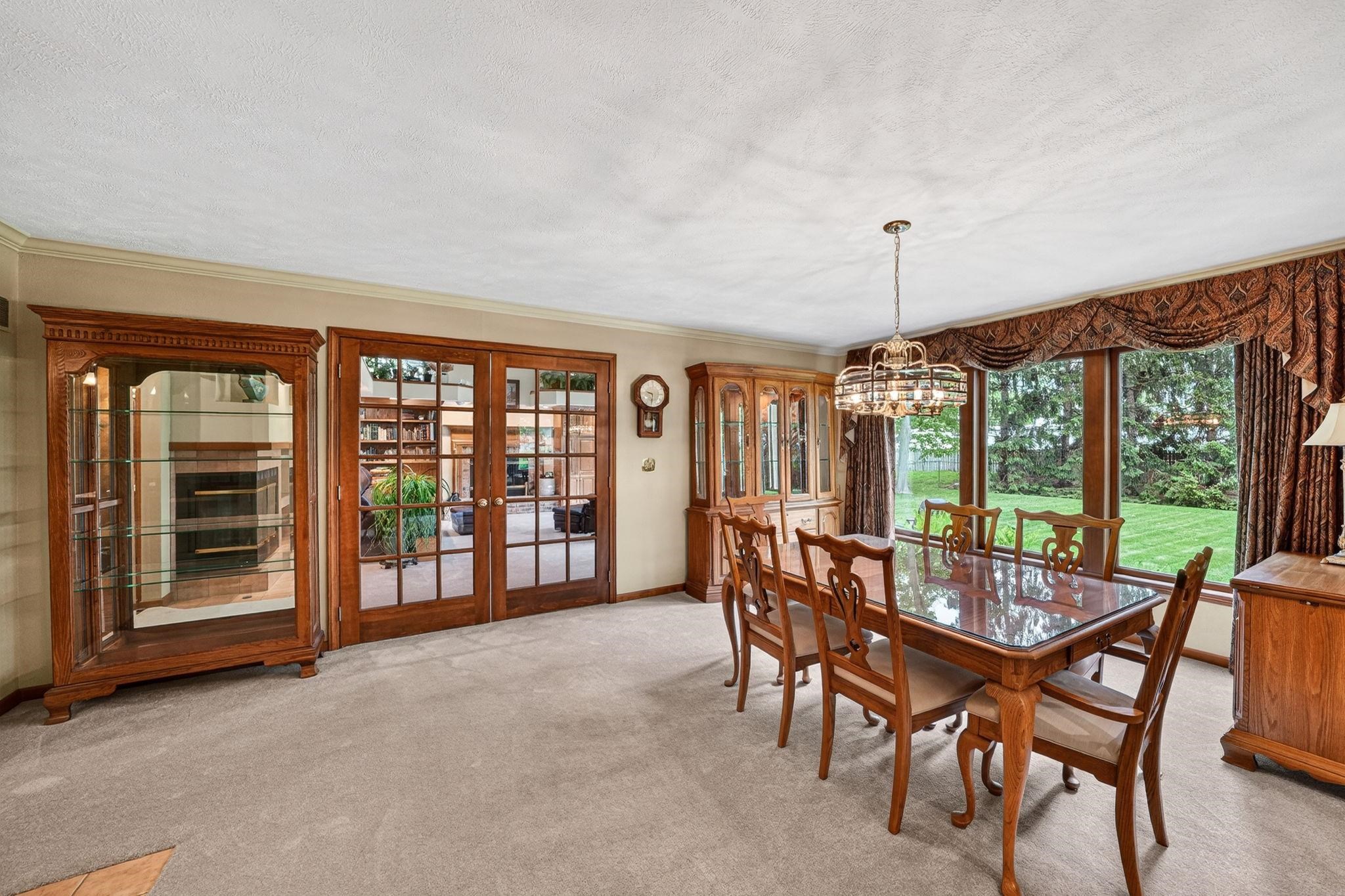 Dining area featuring French doors, a large picture window, and carpeted flooring