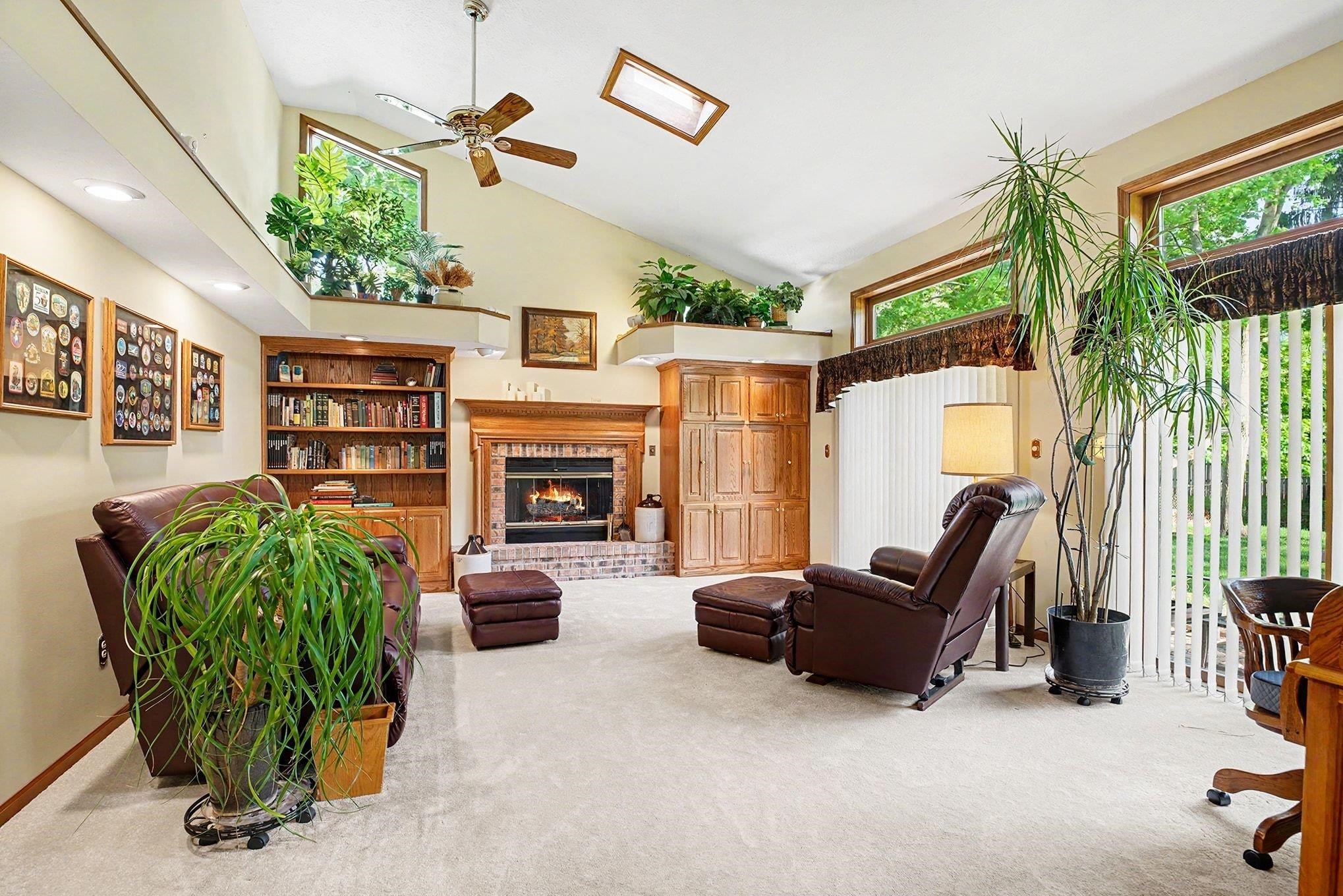 Spacious living area featuring a vaulted ceiling with a skylight, a ceiling fan, and recessed lighting