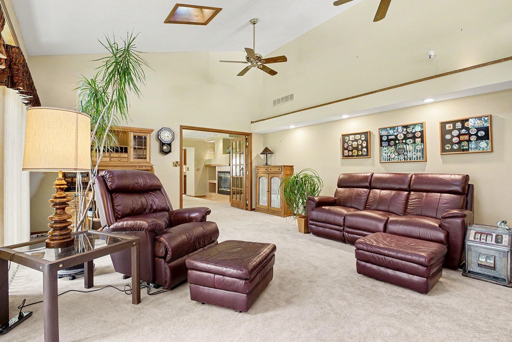 Spacious living area featuring a vaulted ceiling, recessed lighting, and a skylight