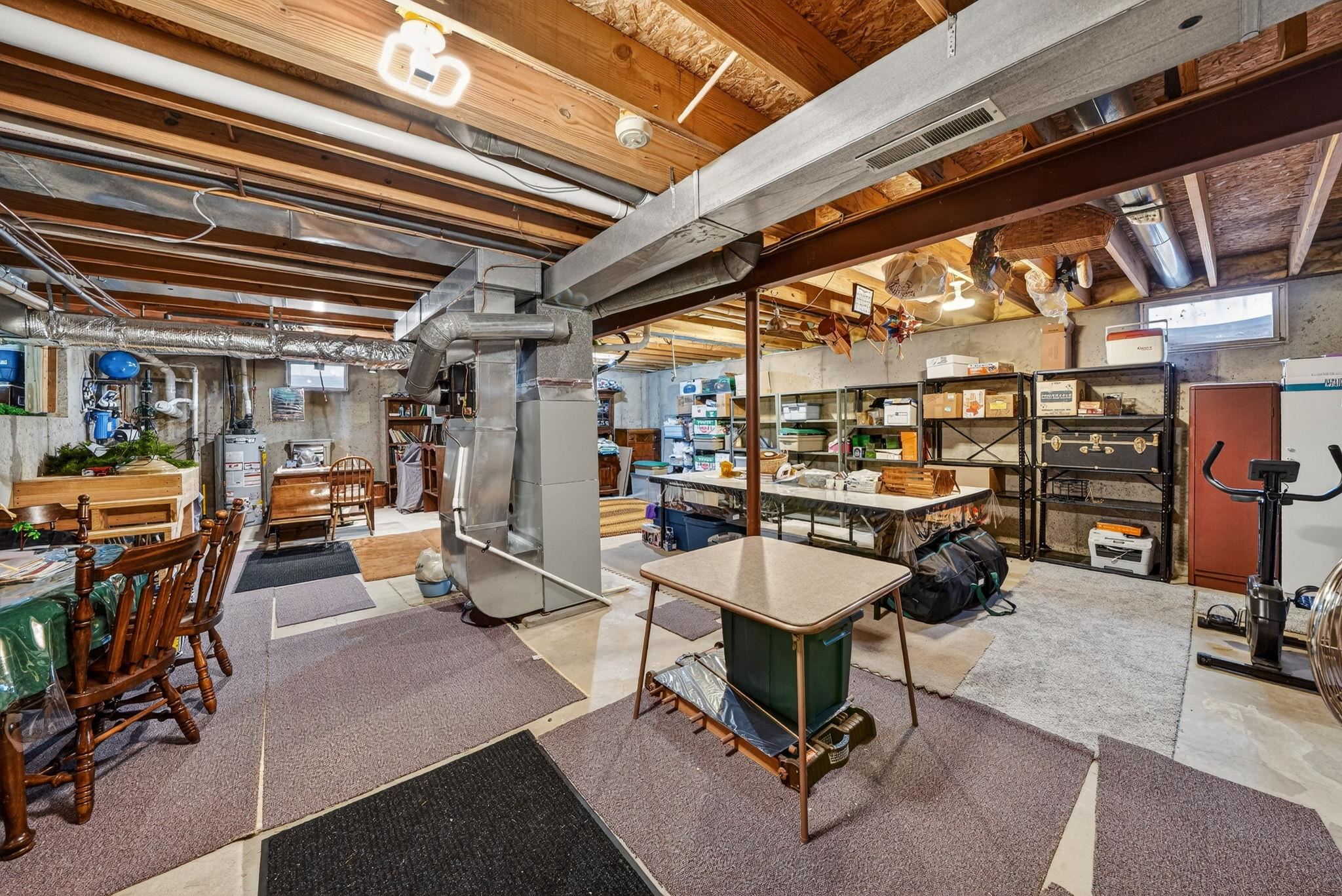 Unfinished lower level featuring exposed ceiling joists and concrete flooring