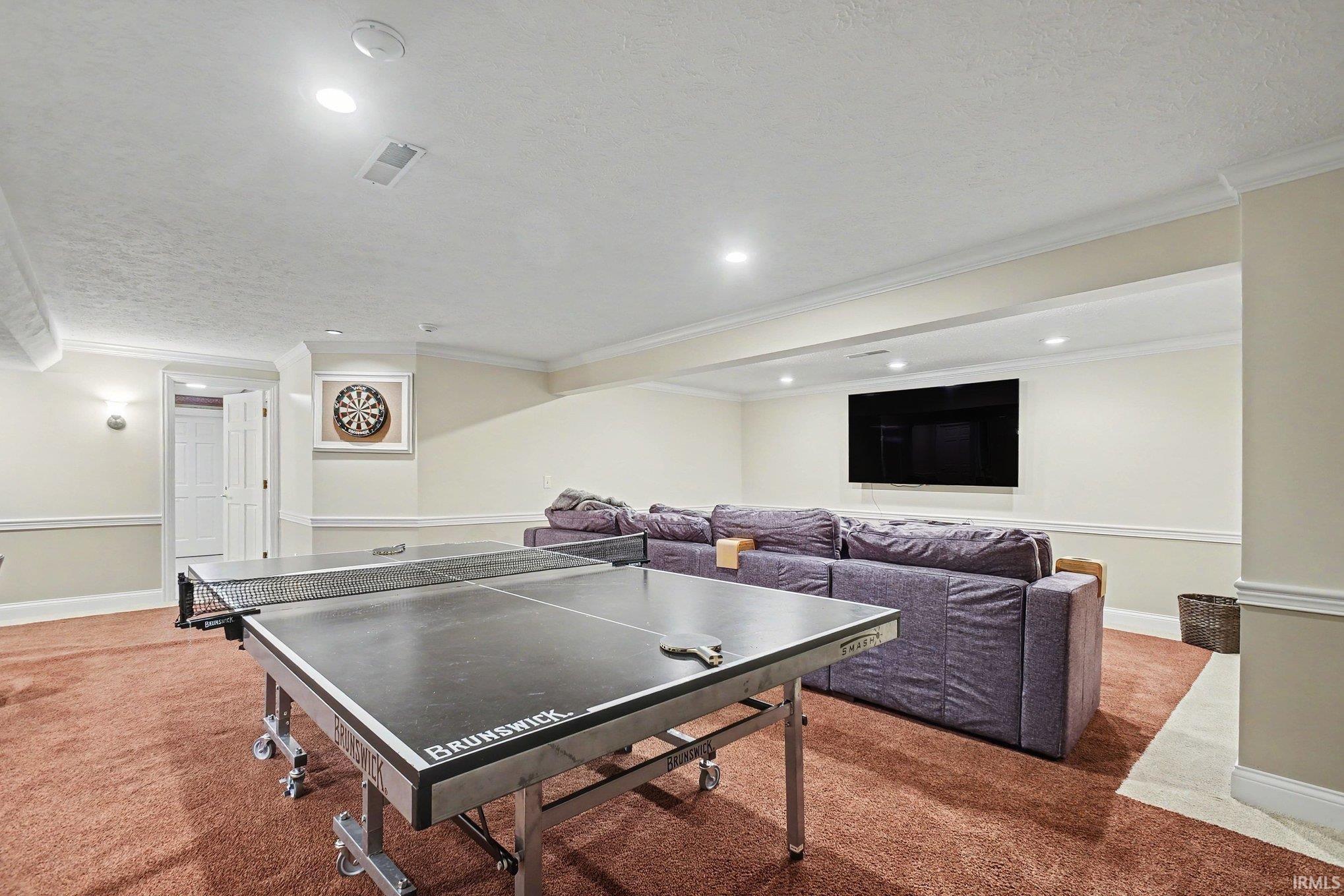 Expansive recreation room featuring soft carpet flooring and recessed lighting