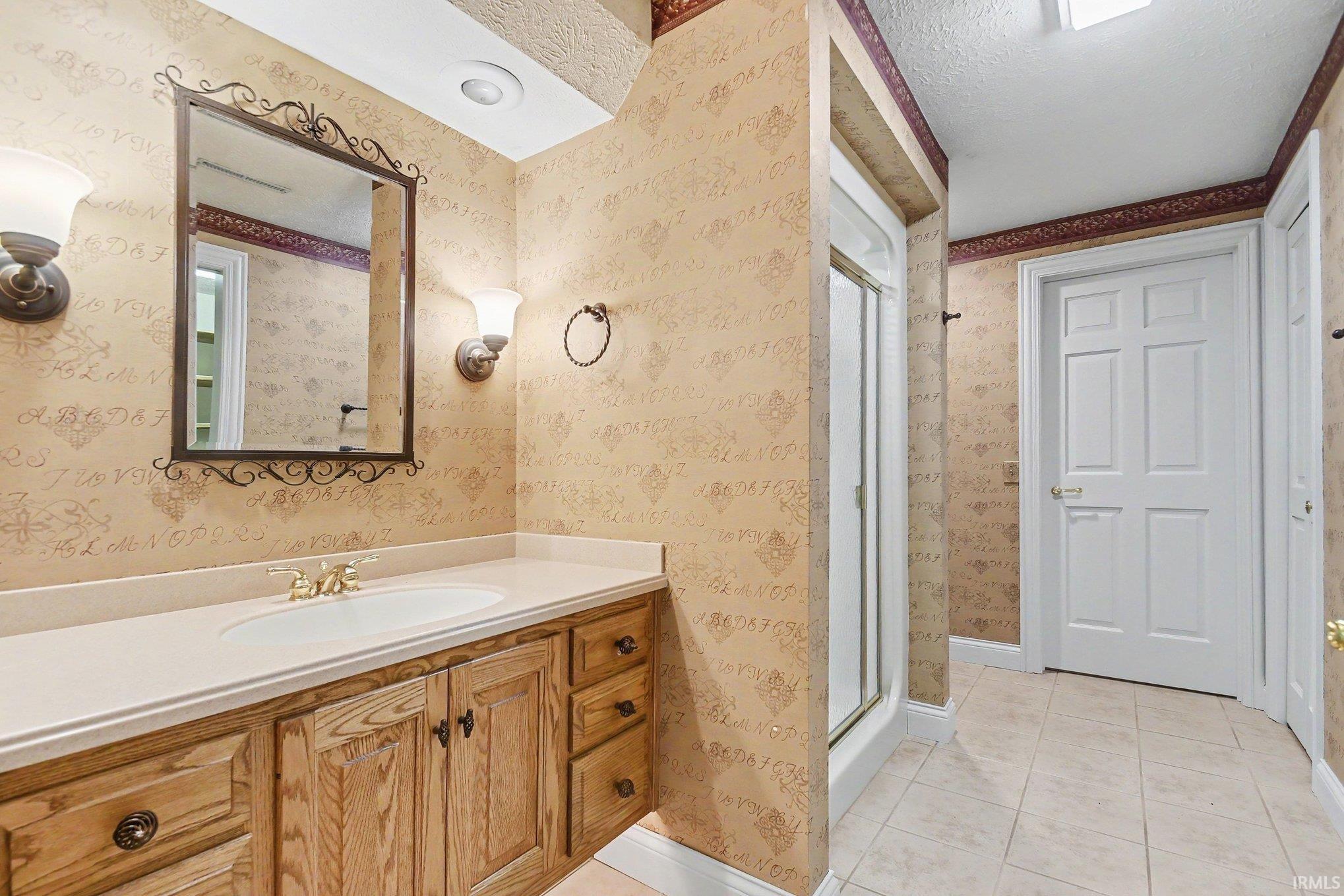 Bathroom vanity featuring a light-toned countertop, integrated sink, and wood-finish cabinetry