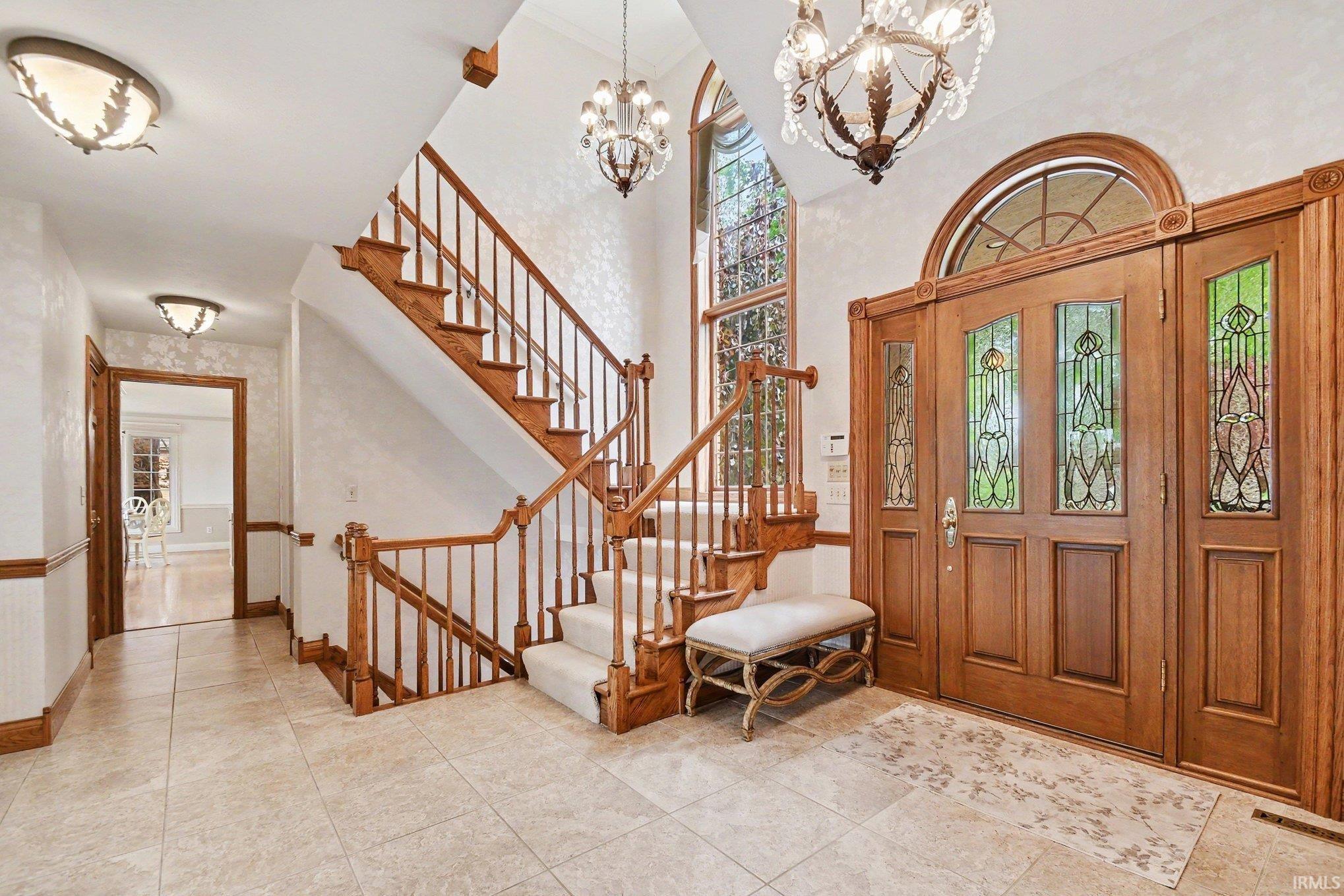 Foyer featuring a grand staircase with wood banisters and carpeted treads