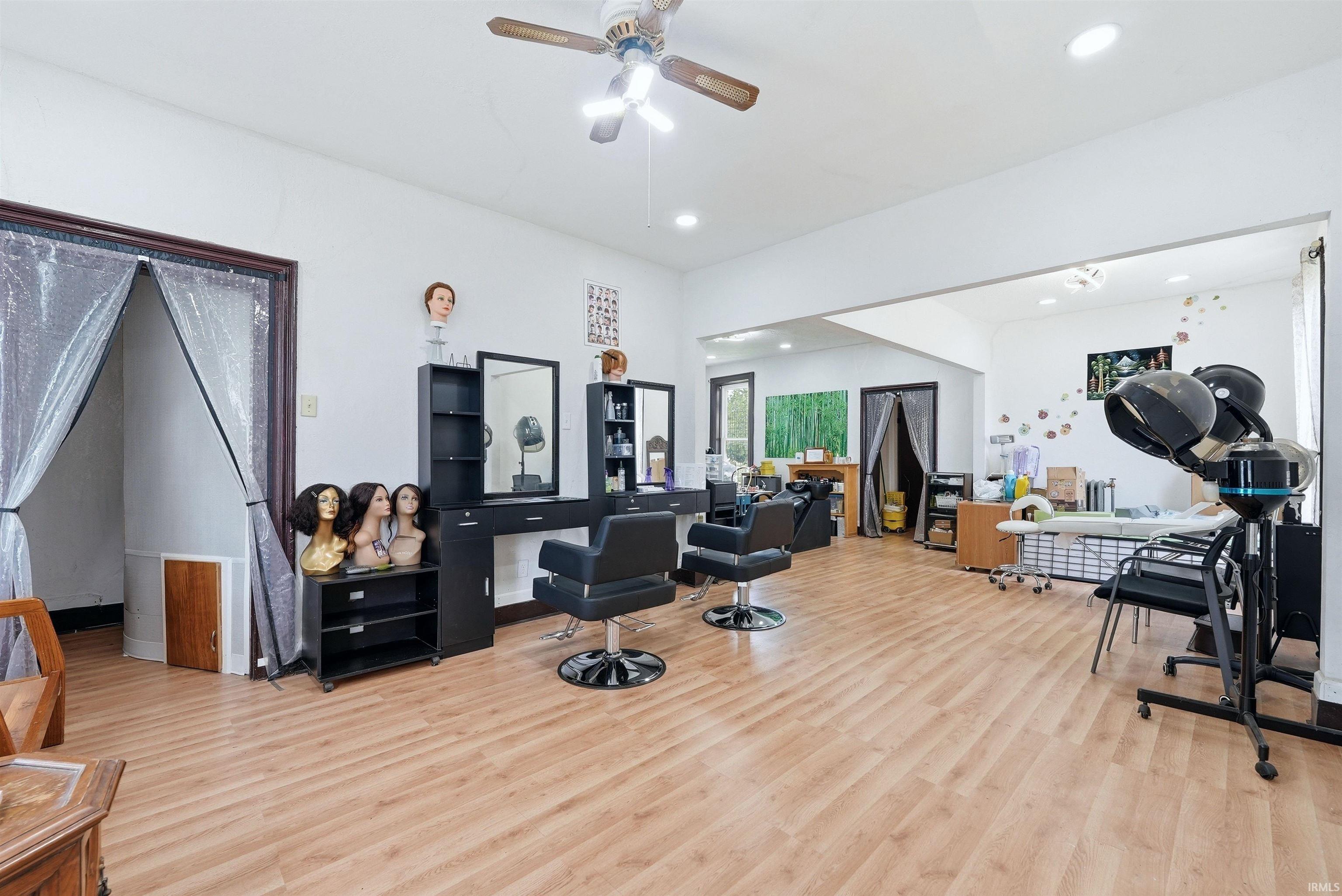 Open-concept commercial space featuring light wood-finish flooring, white walls, and recessed lighting