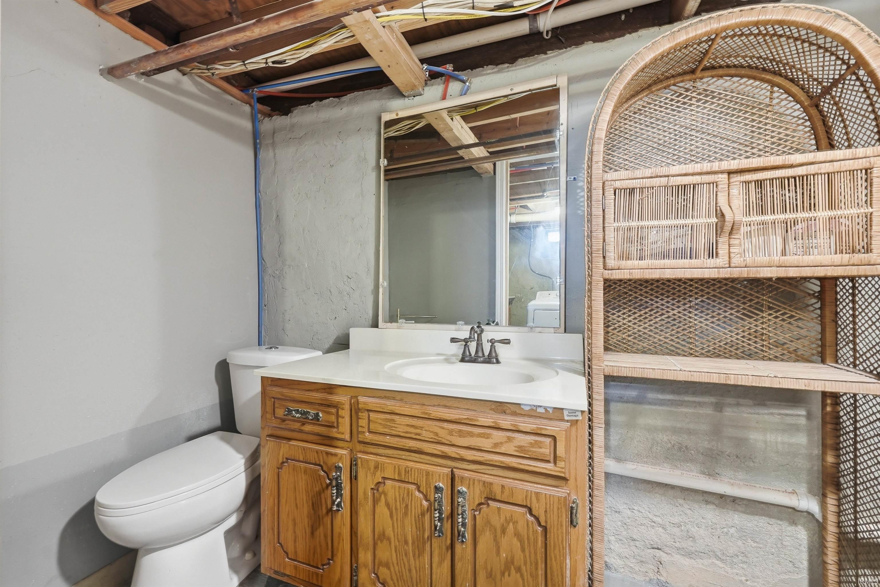 Bathroom featuring a single vanity with a white countertop and an undermount sink