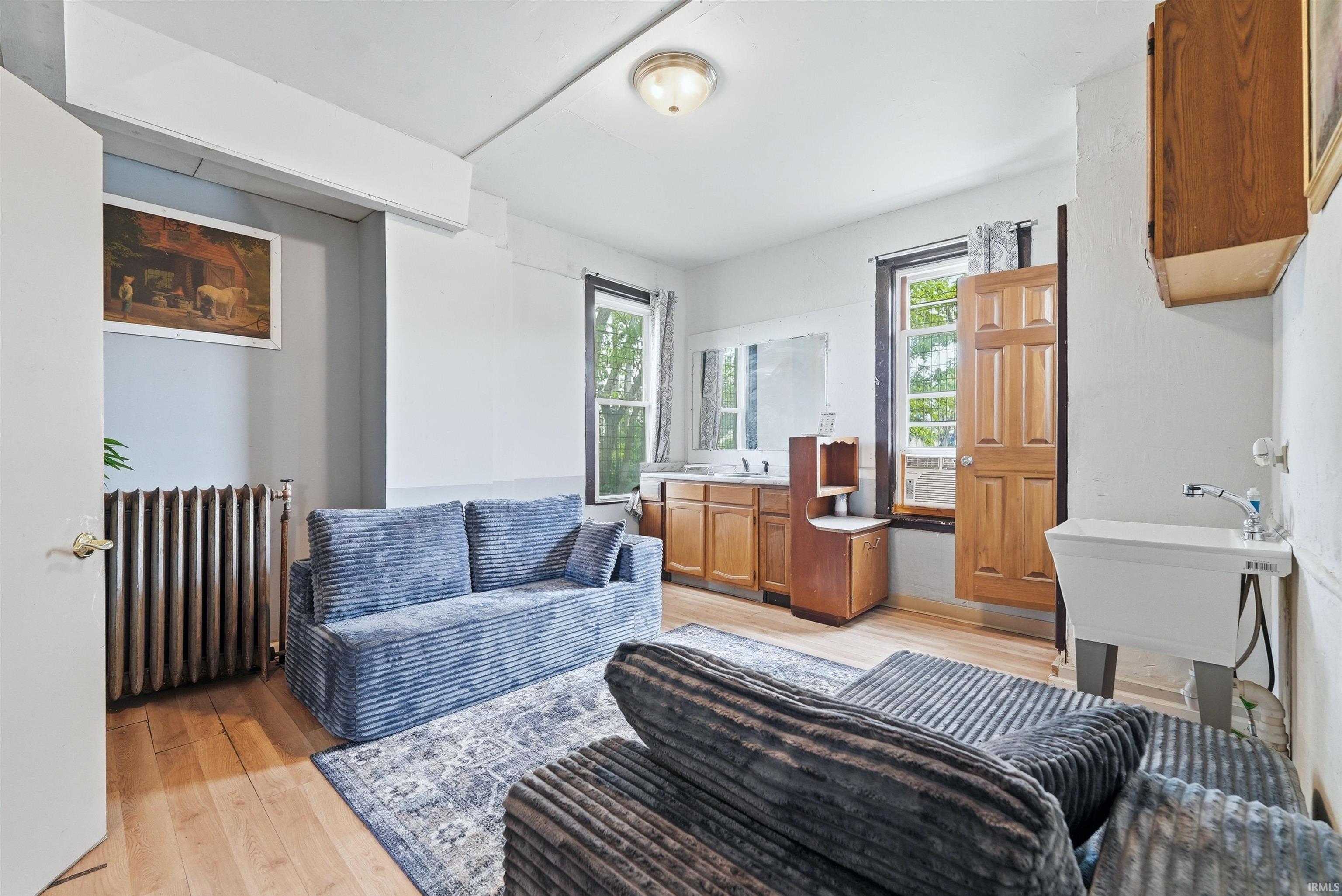 Back room living space. Light wood-finish flooring complements the white wall finishes