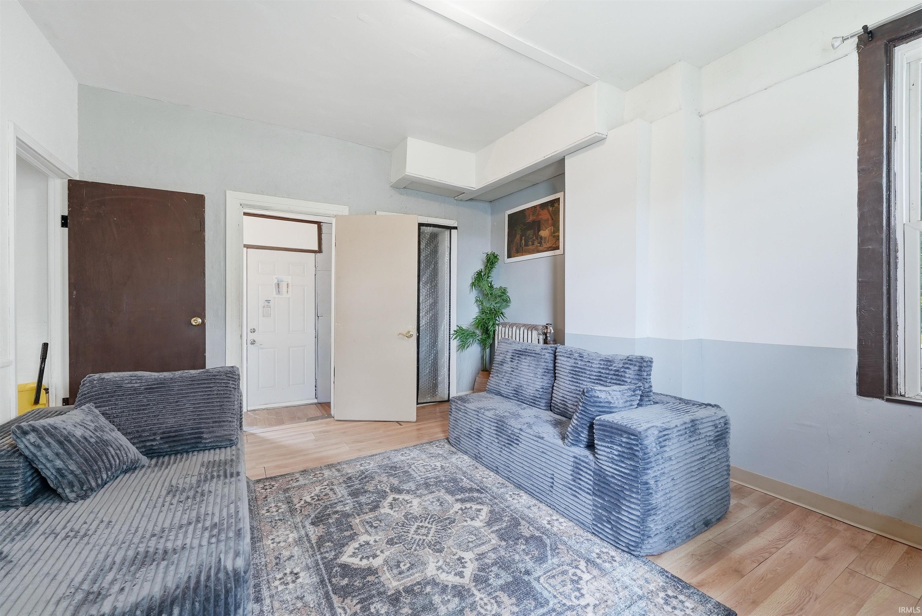Back room living space. Light wood-finish flooring complements the two-tone wall treatment