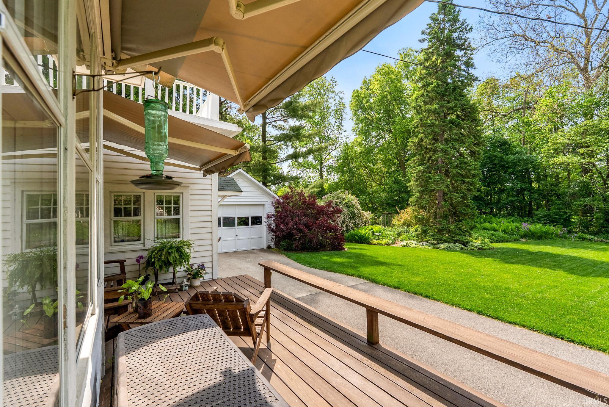 Expansive exterior deck featuring wood-finish decking and a light-colored retractable awning