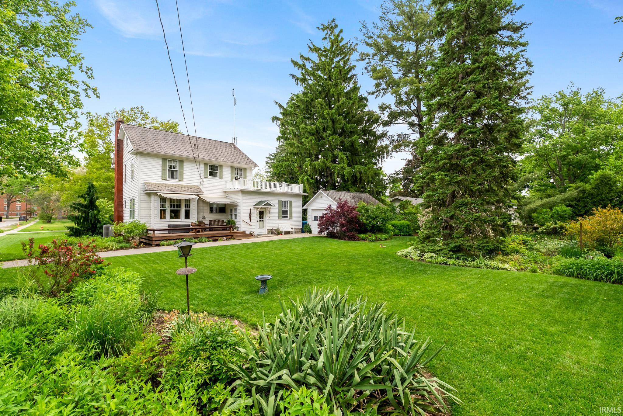 Expansive green lawn with mature trees and diverse landscaping