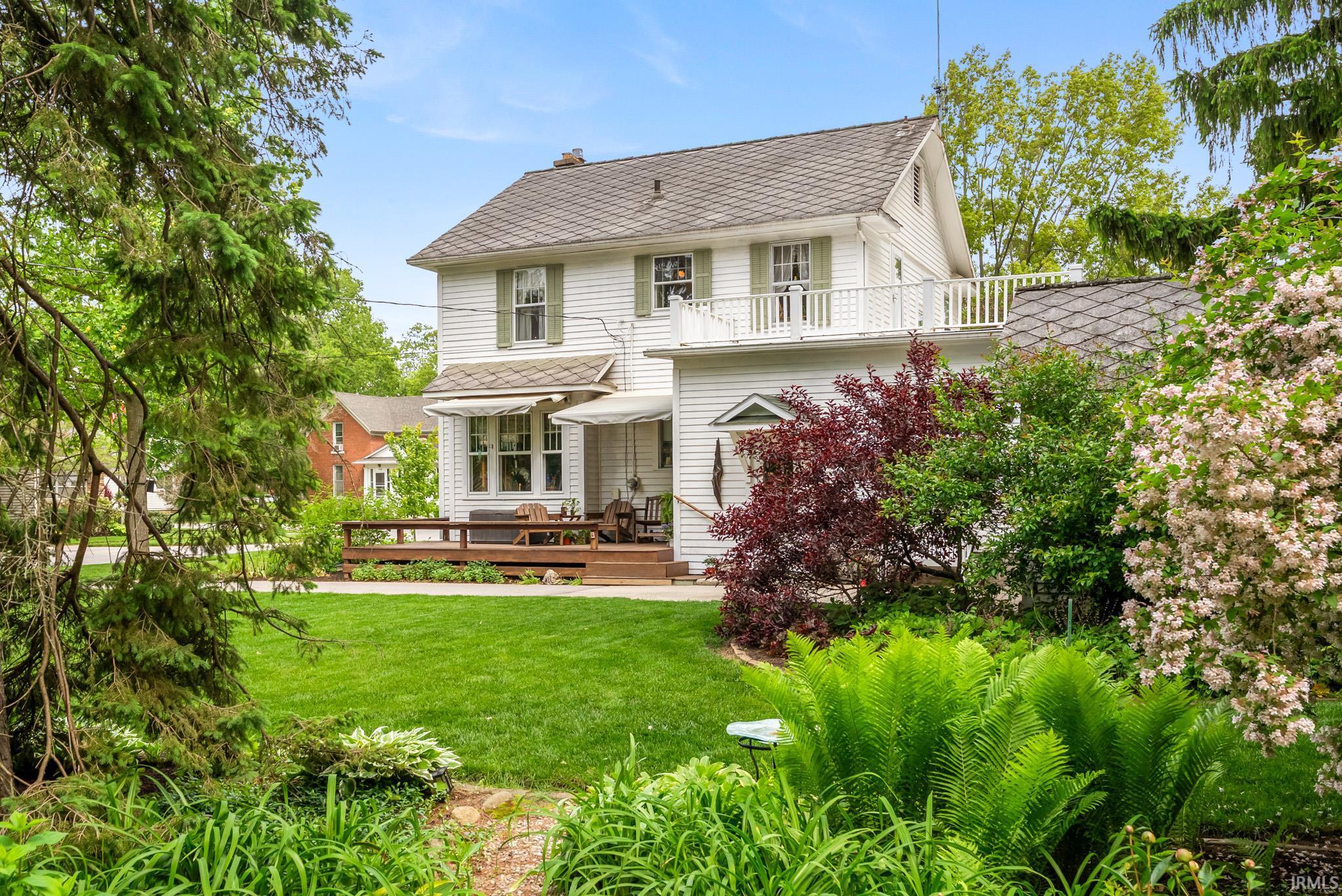Expansive green lawn with mature trees and diverse landscaping