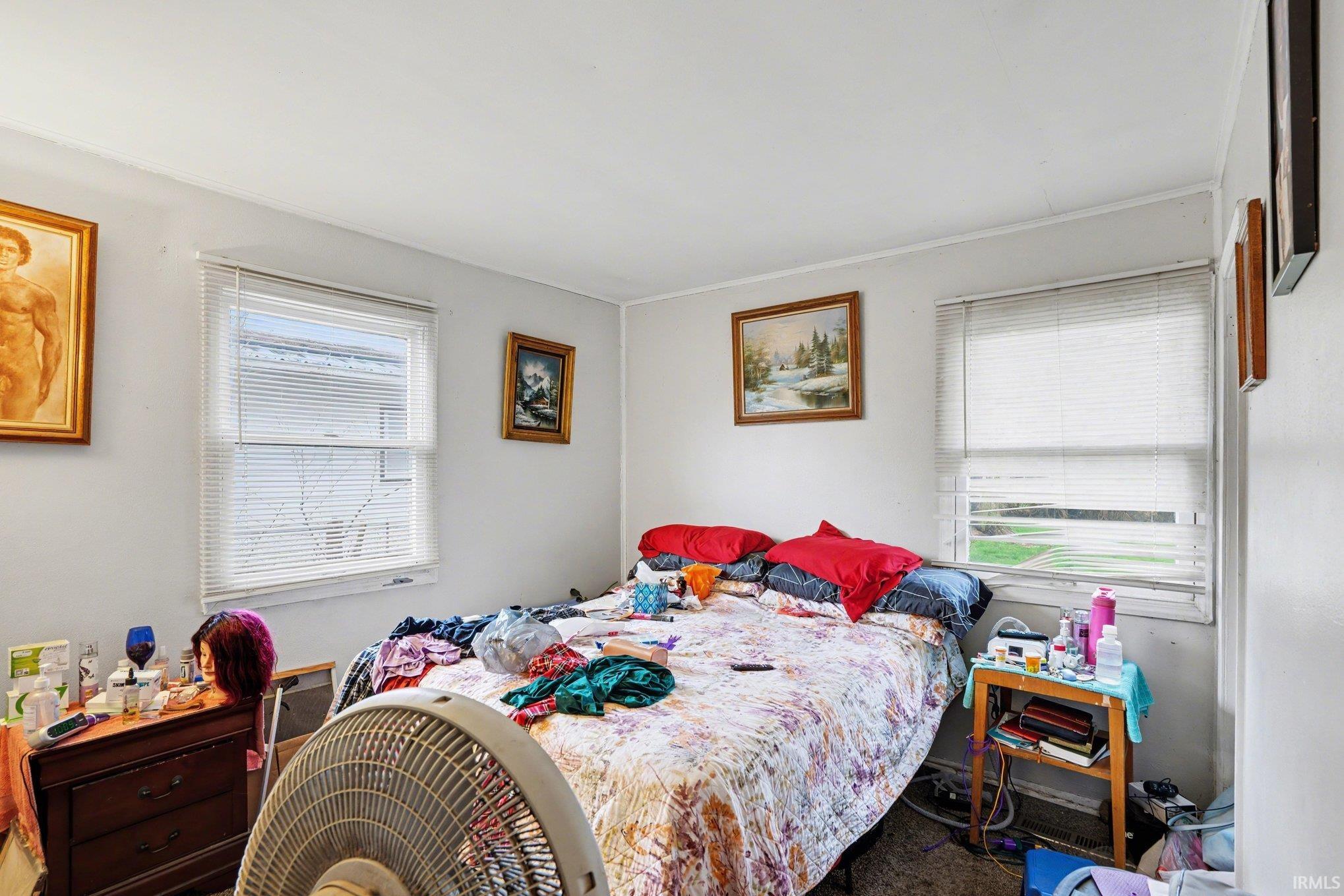 White walls with crisp trim, two windows featuring horizontal blinds, and a light-colored ceiling