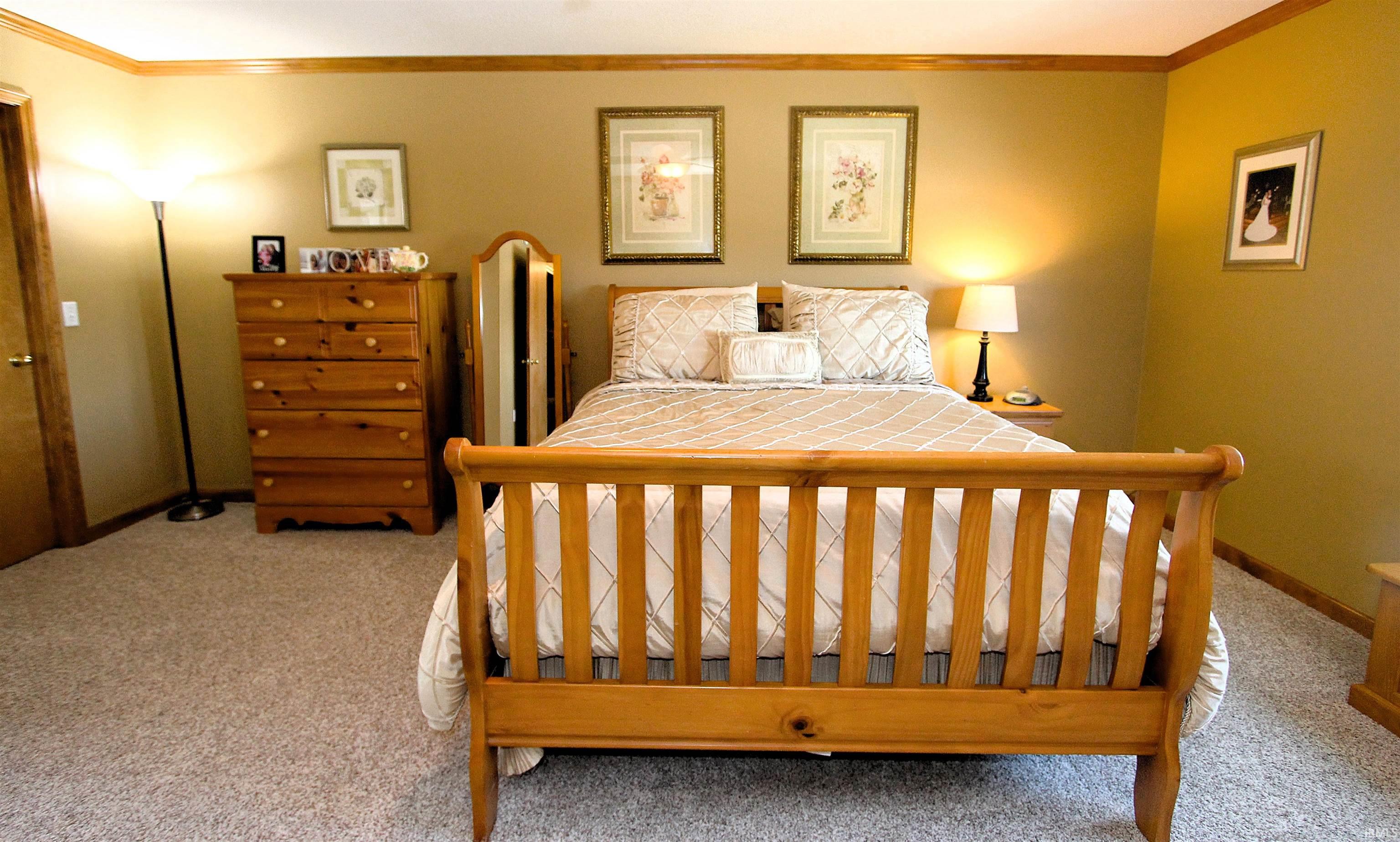 Carpeted room with a wooden bed frame and complementary wooden trim
