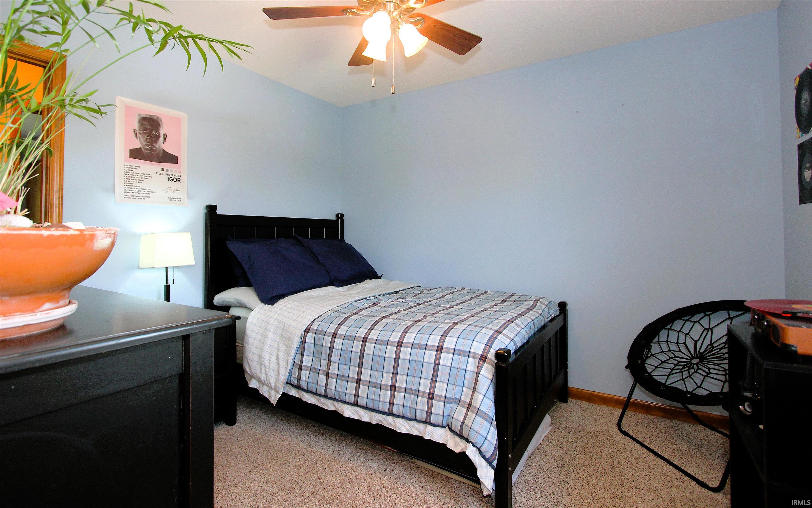 Bedroom featuring light blue walls and neutral carpet flooring