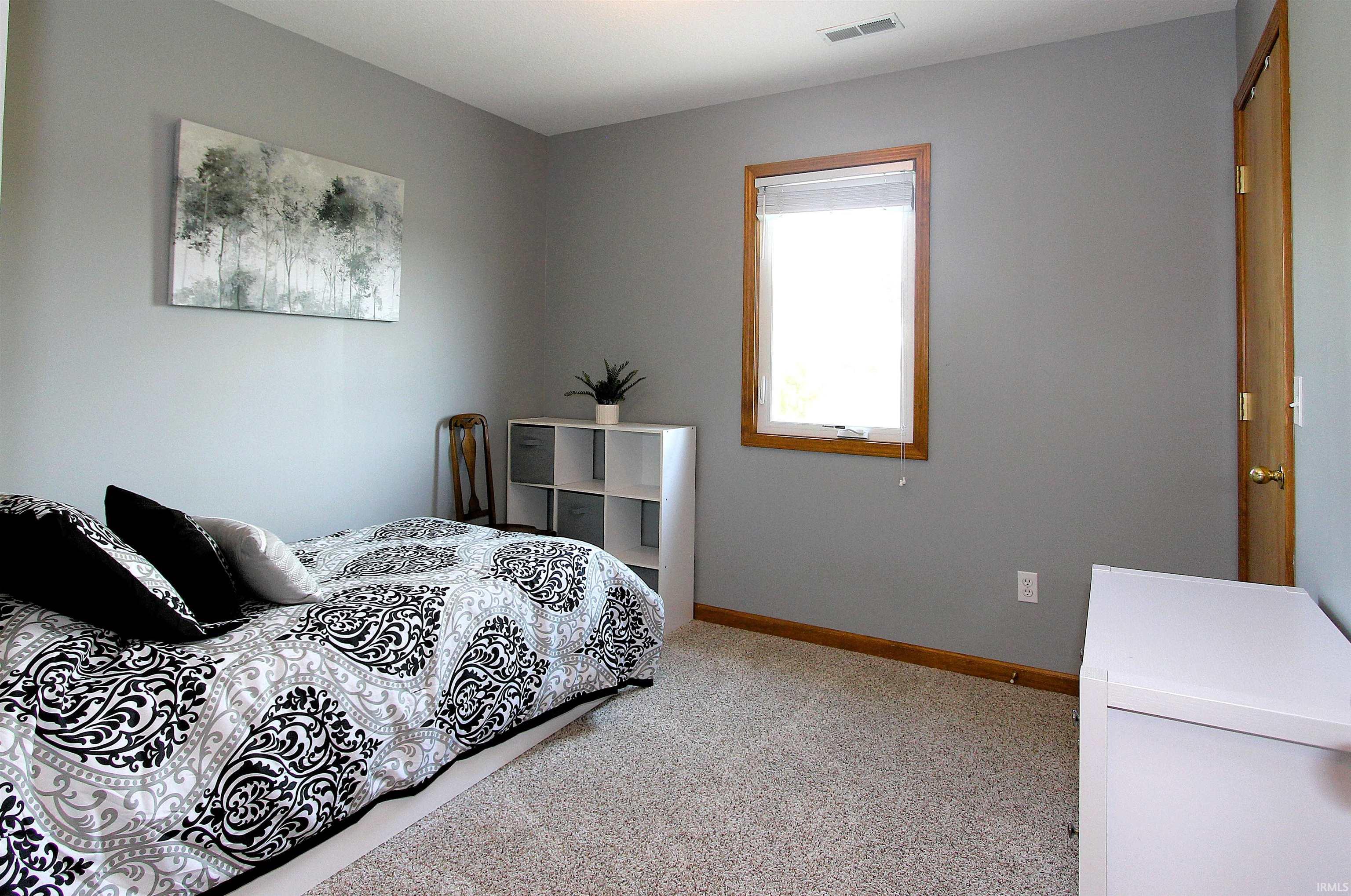 Carpeted room featuring a single window with wood trim, a wood-paneled door, and recessed lighting