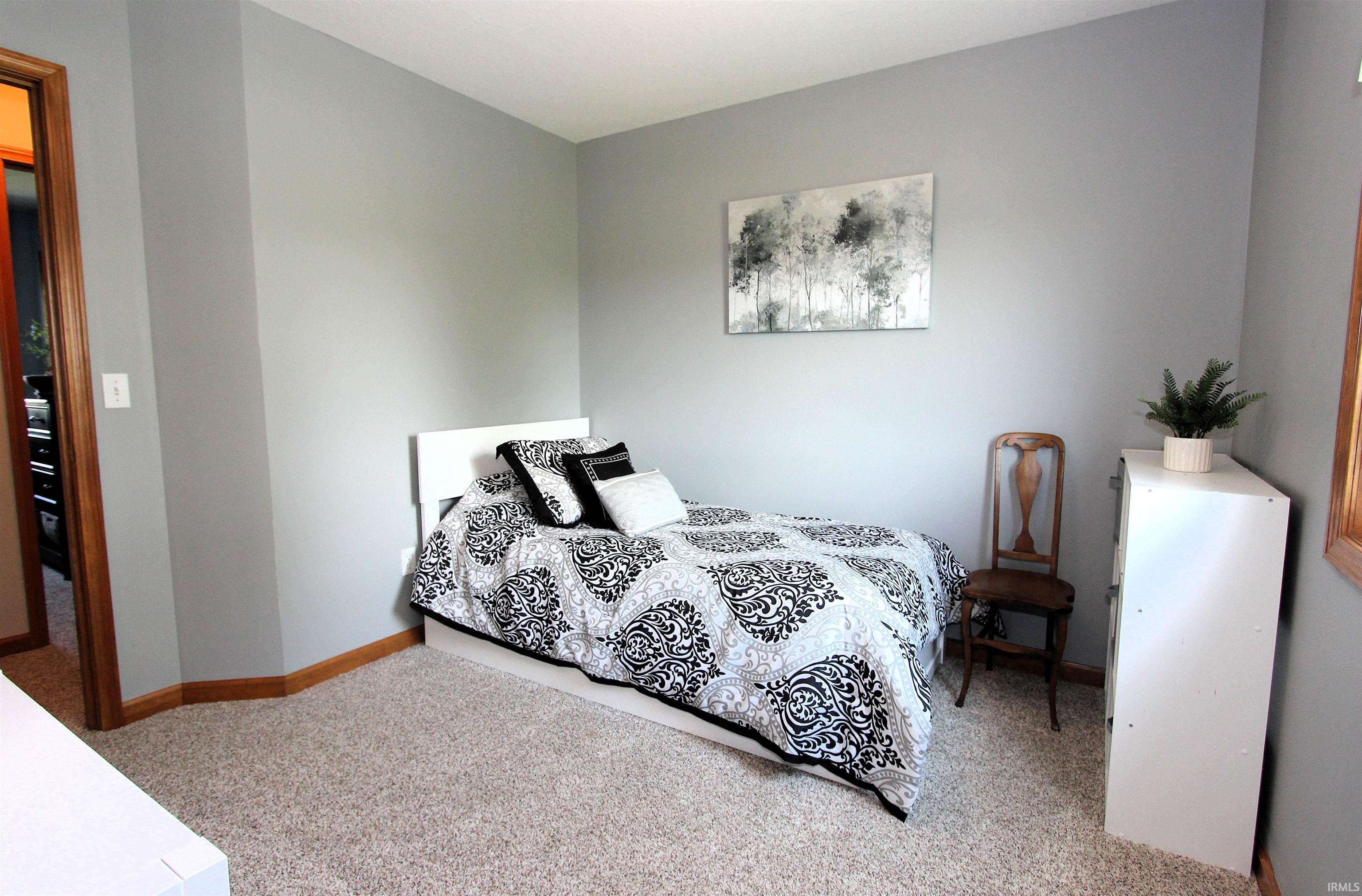 Carpeted room featuring light gray walls and wood-finish trim