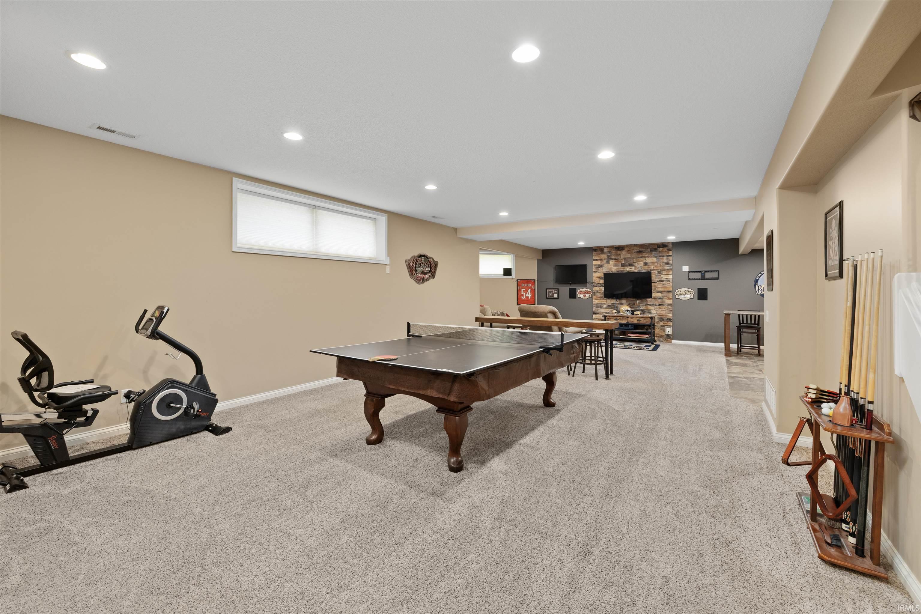 Spacious lower level featuring recessed lighting, light-colored carpeting, and a stone accent wall