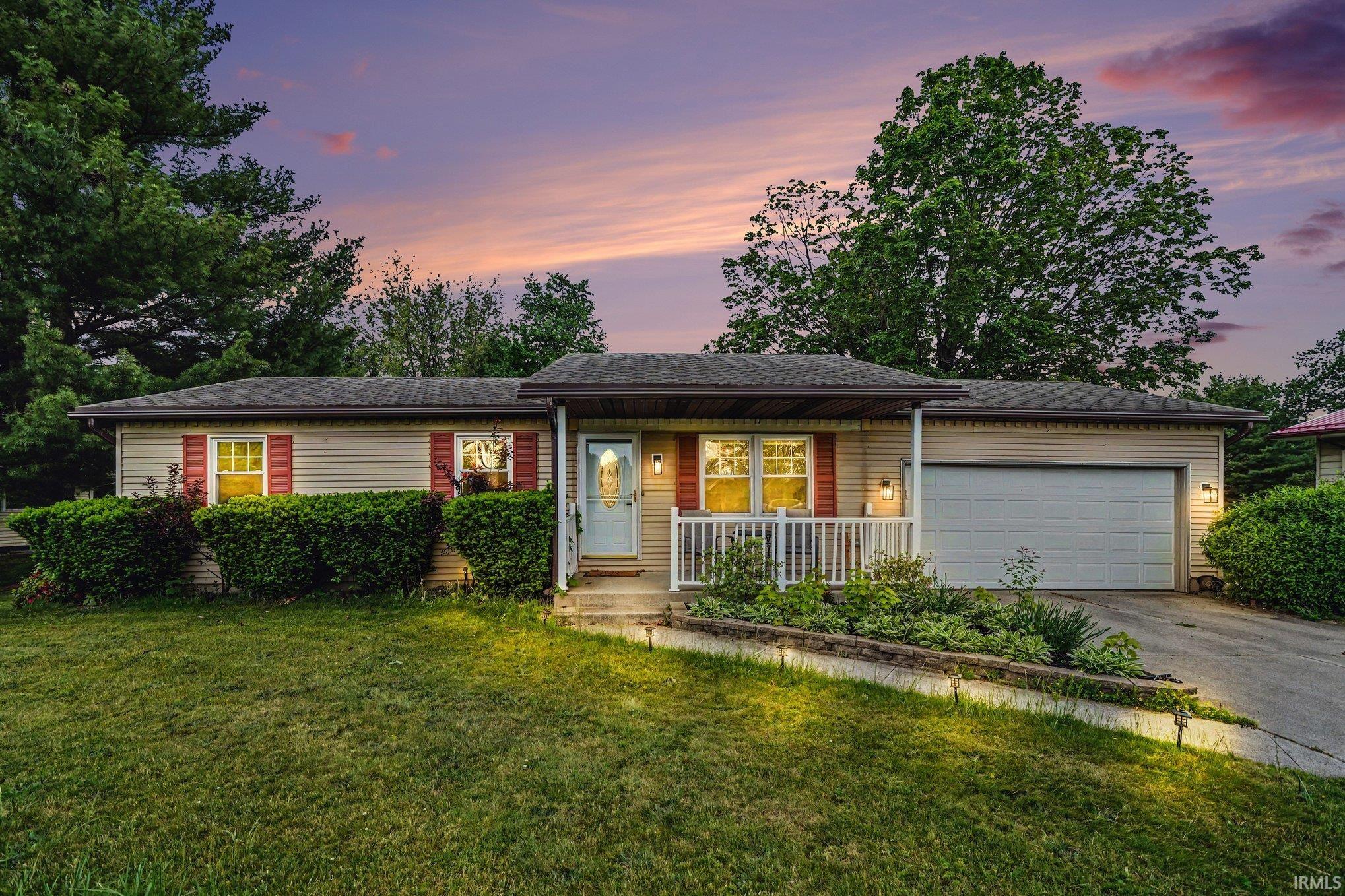 Ranch-style exterior featuring beige siding with red window shutters