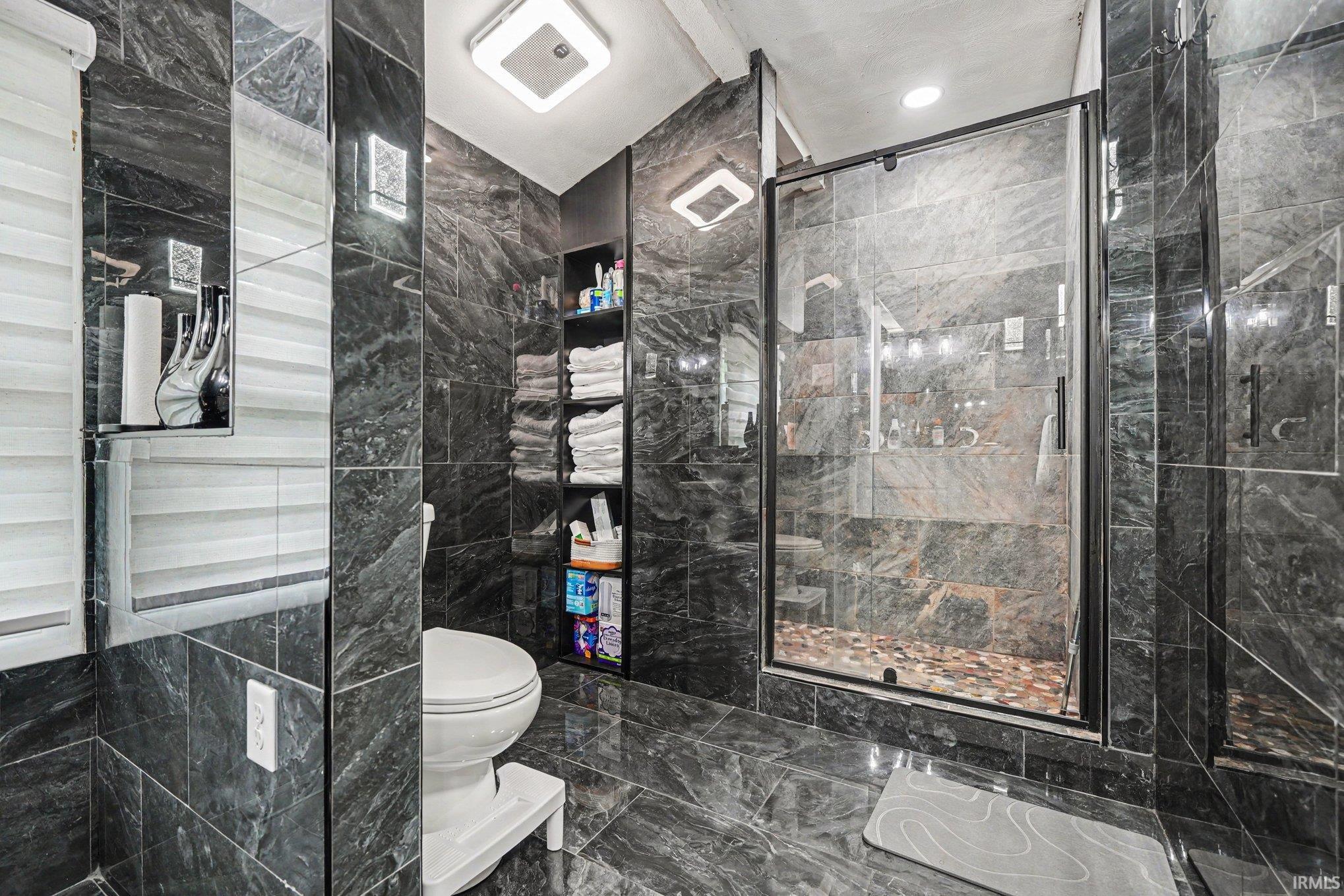 Contemporary bathroom featuring a spacious glass-enclosed shower with pebble flooring