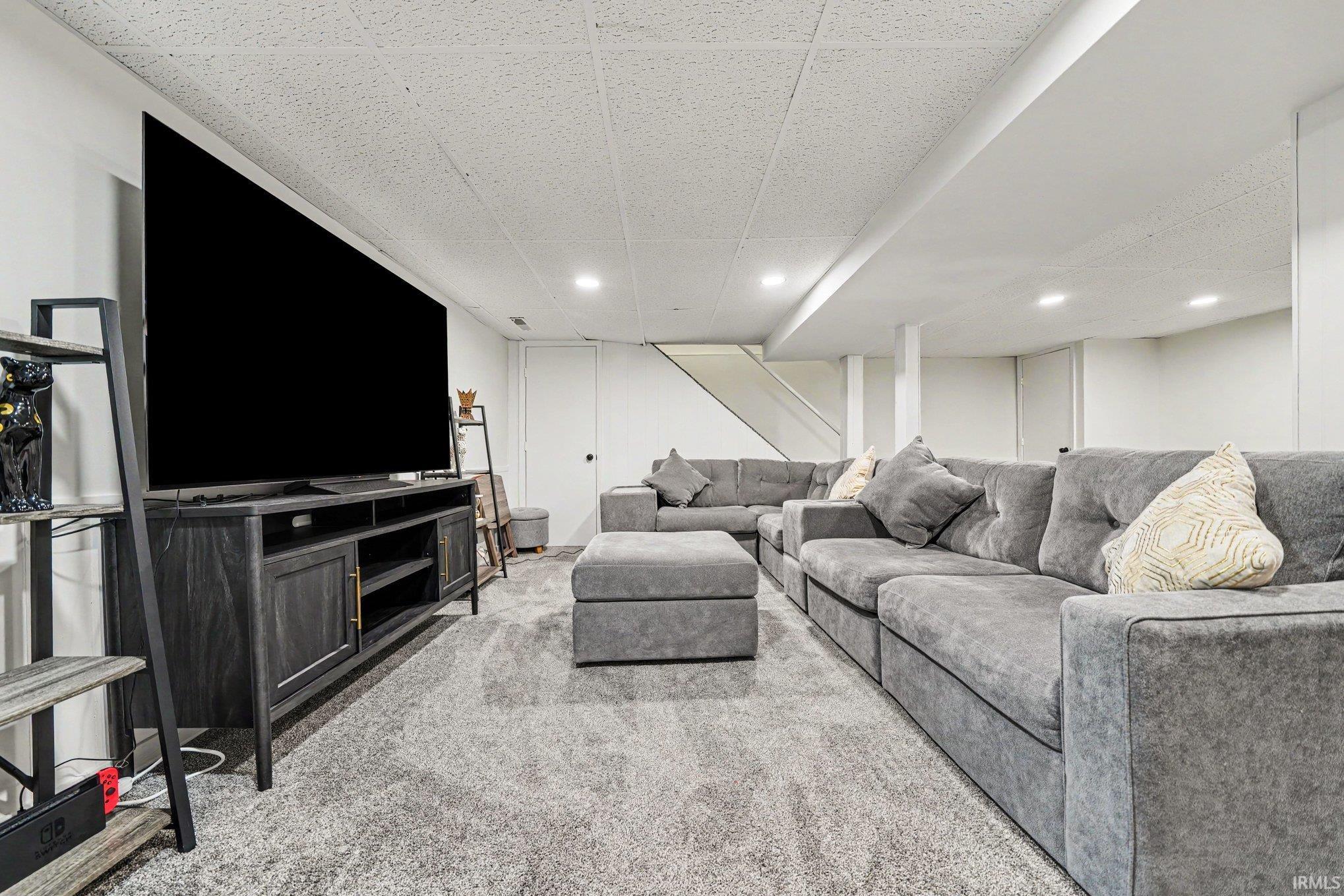 Expansive finished space featuring recessed lighting, a drop ceiling, and light gray wall paint