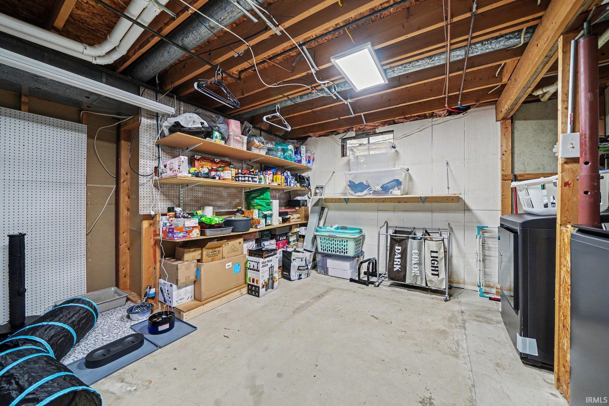 Unfinished basement with concrete flooring and exposed ceiling beams