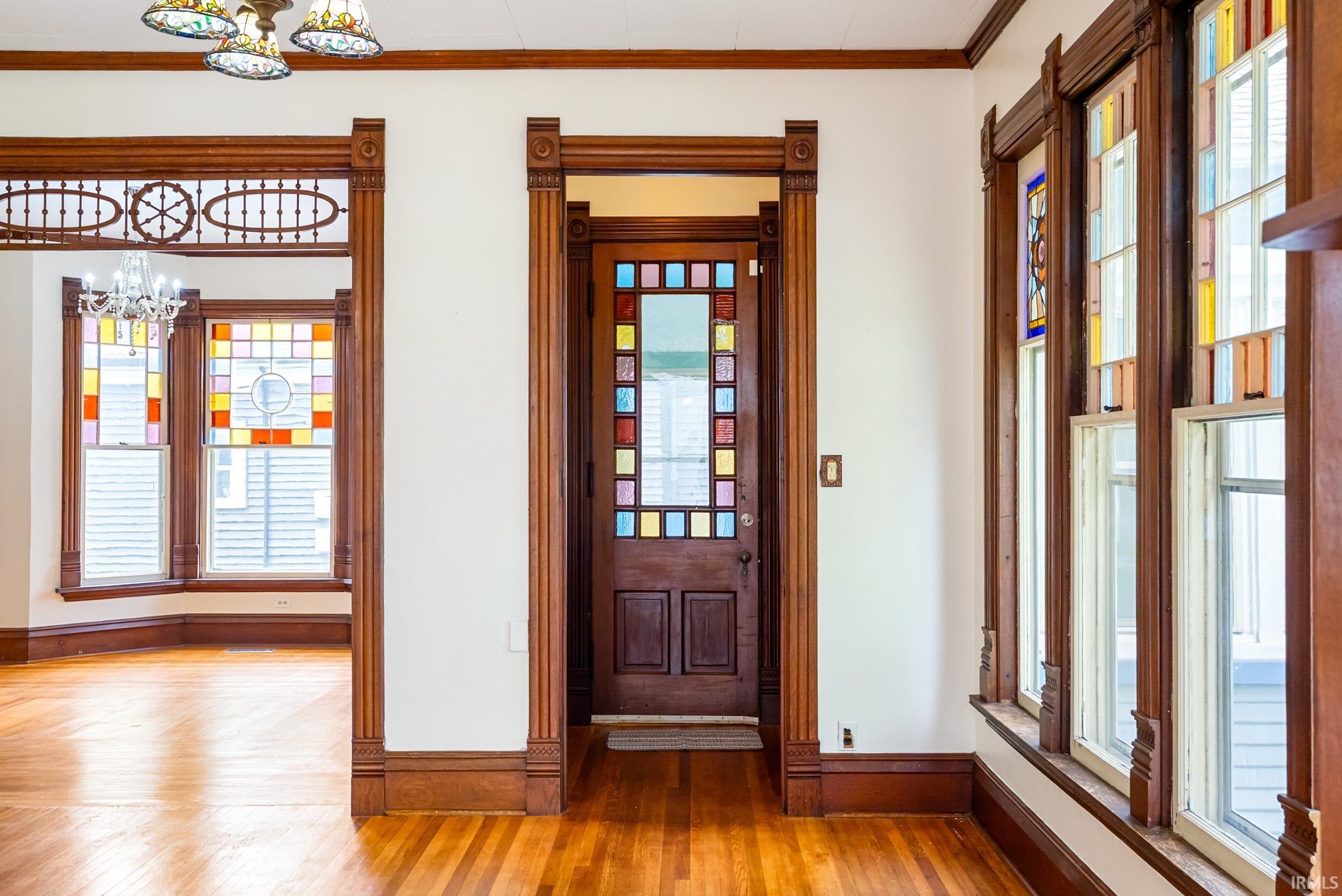 Rich wood trim throughout, including a decorative entryway with a stained glass door