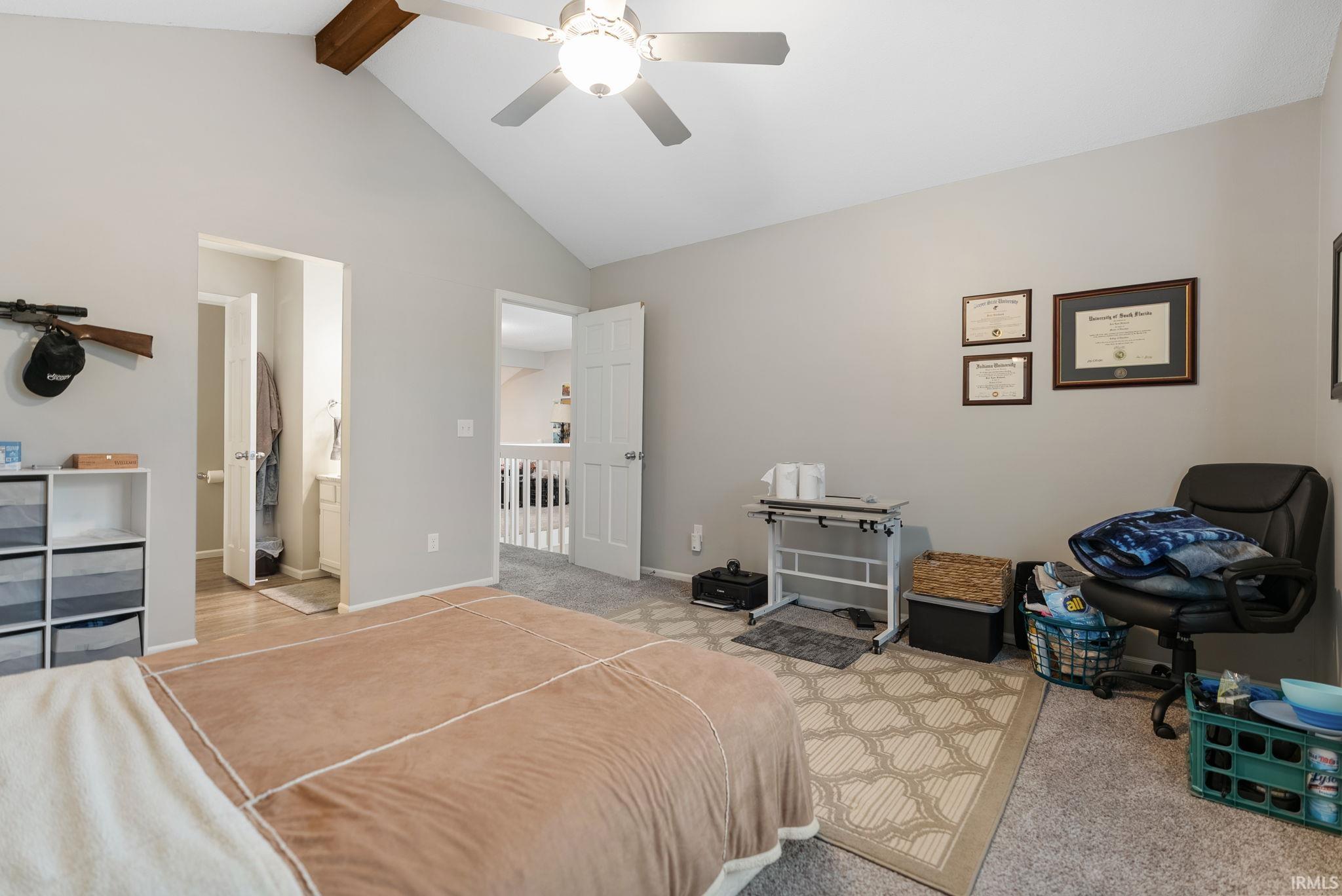 Vaulted ceiling room featuring a ceiling fan with integrated lighting, wood-finish beam, and carpet flooring