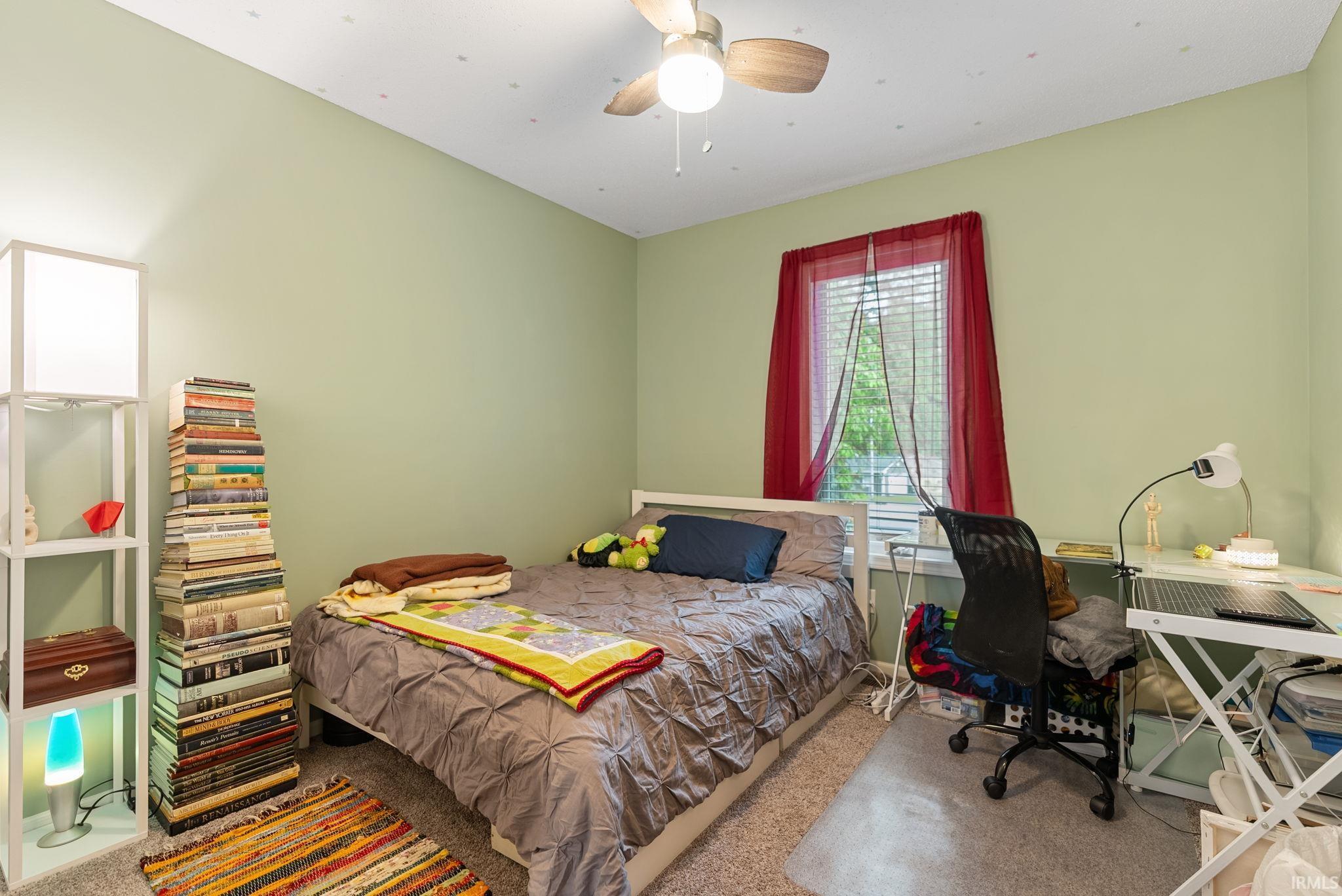 Bedroom featuring a window with blinds, light green wall paint, and a ceiling fan with integrated lighting