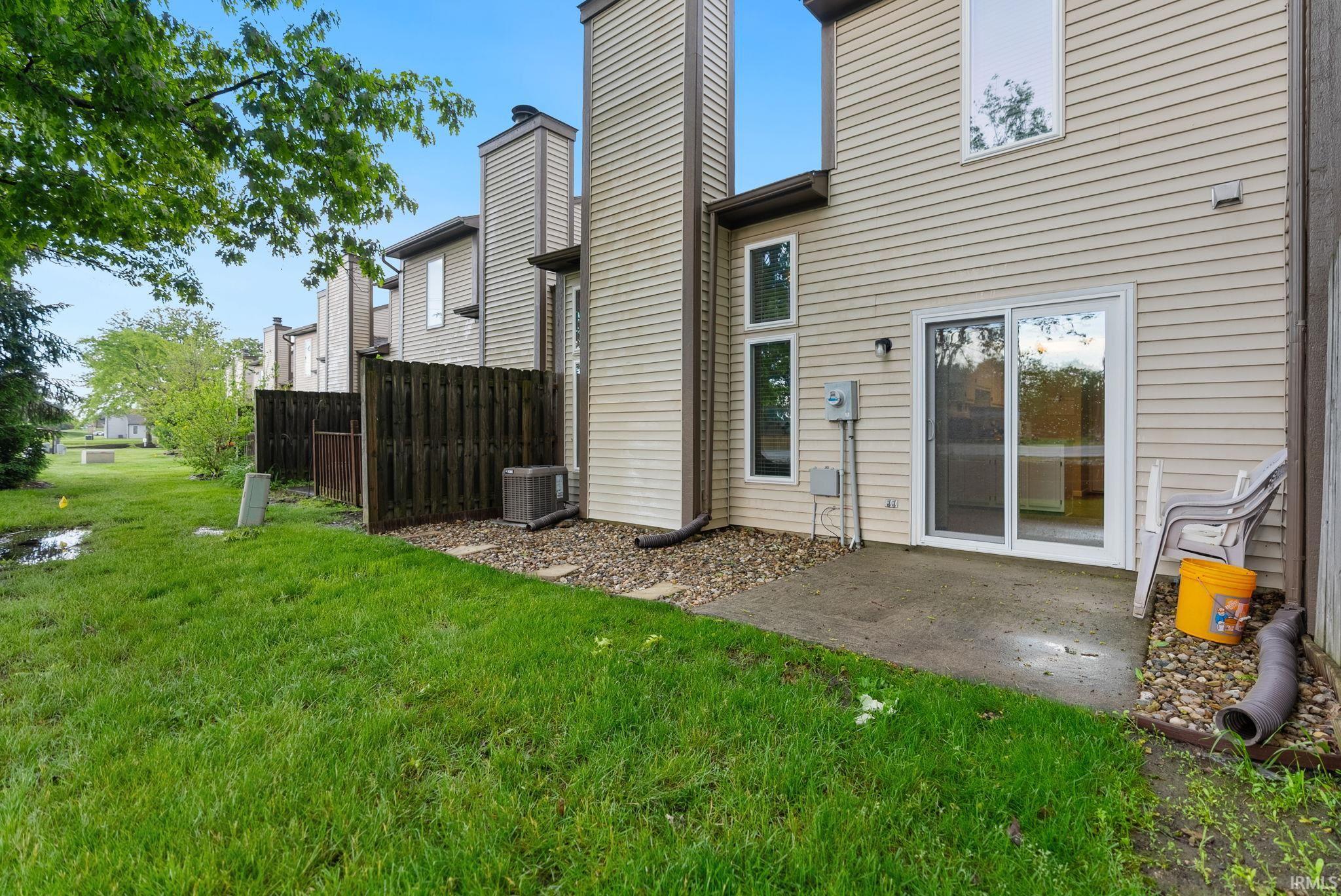 Private patio space featuring a concrete pad and surrounding stone landscaping