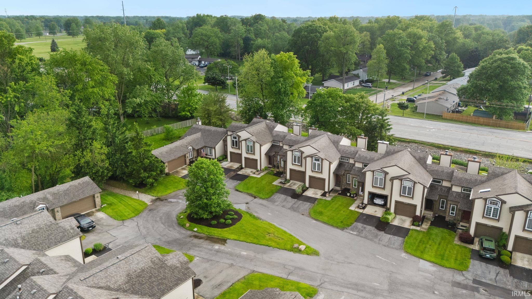 Townhome community featuring individual garage access and mature landscaping