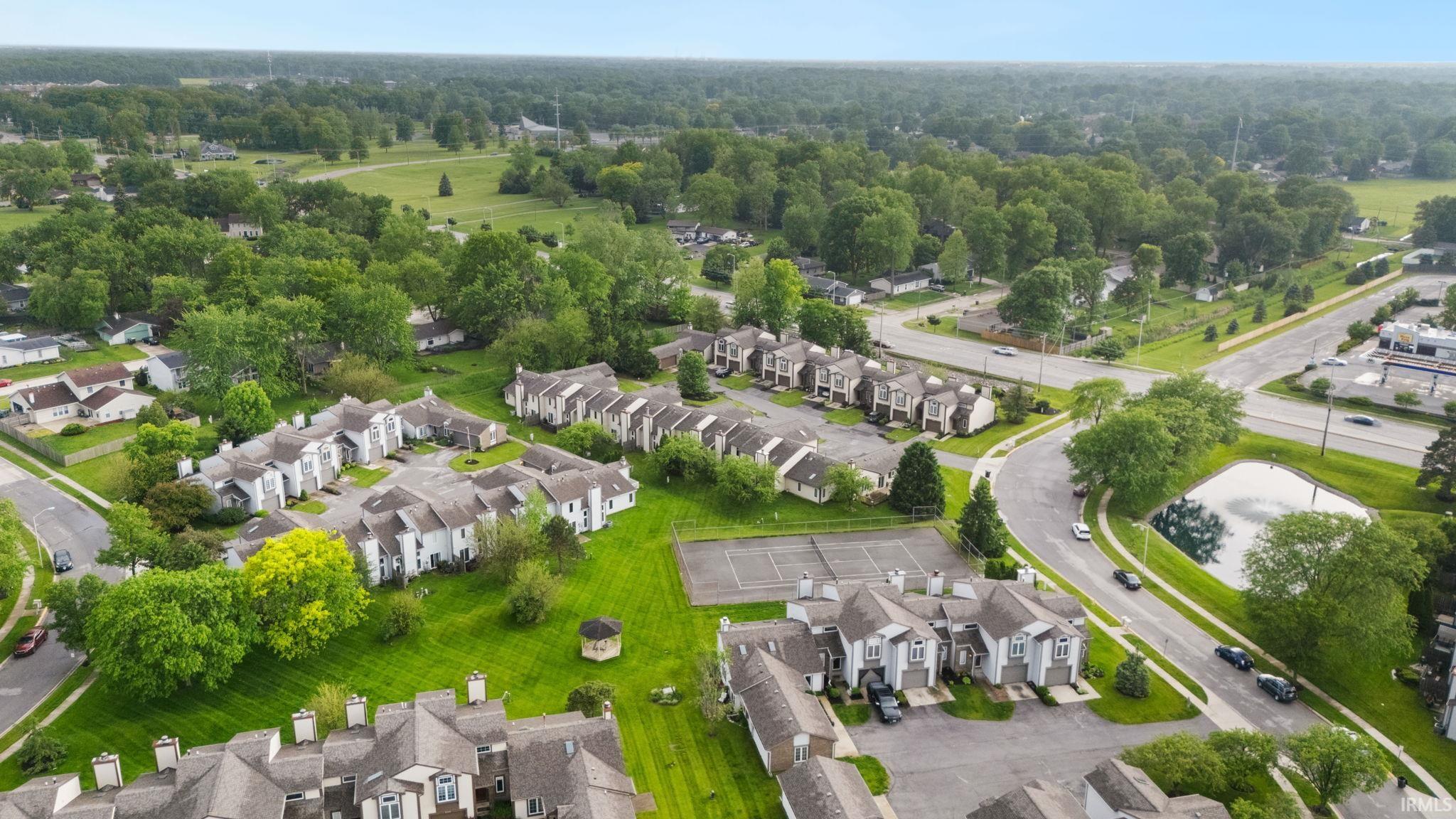 Multi-unit residential complex with varied architectural styles, surrounded by mature trees