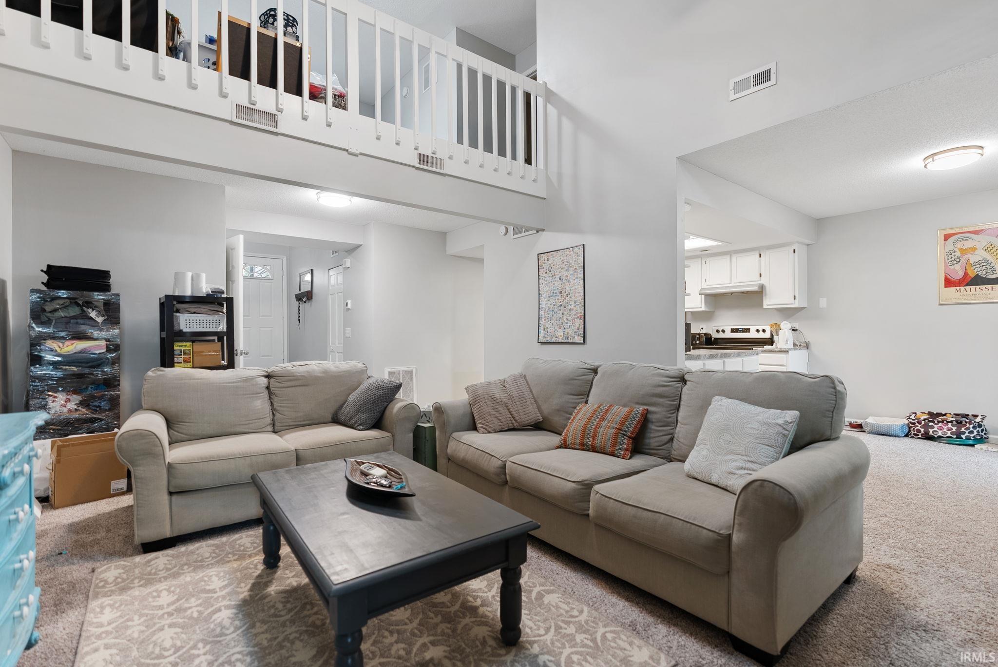 Living area featuring a vaulted ceiling and an open-concept design