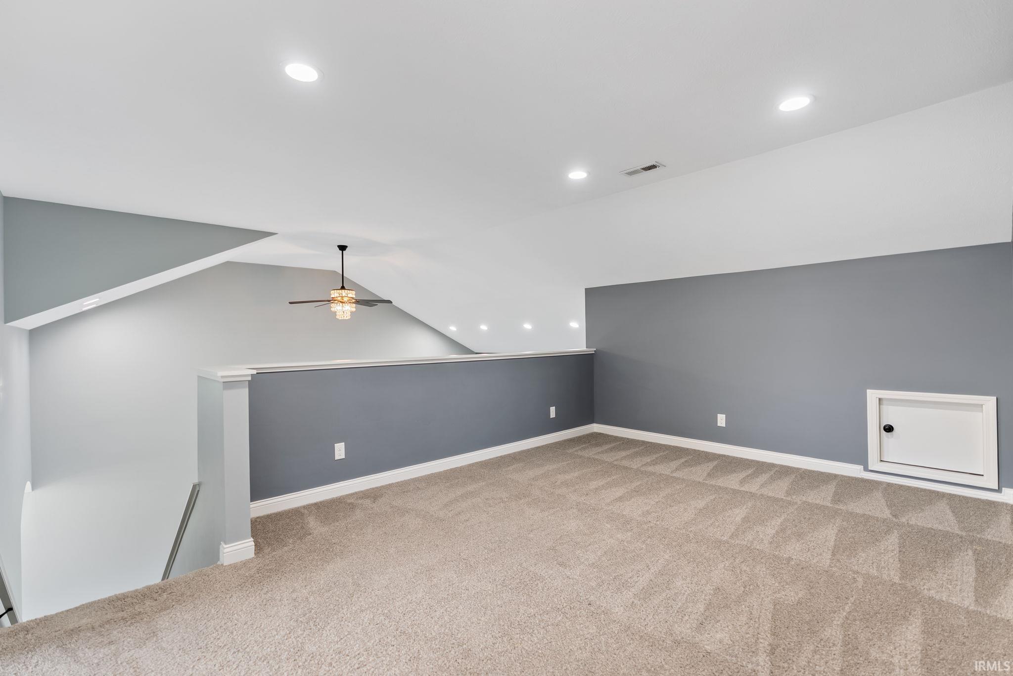 Carpeted loft space featuring recessed lighting, a modern ceiling fan, and a knee wall with a contrasting paint finish