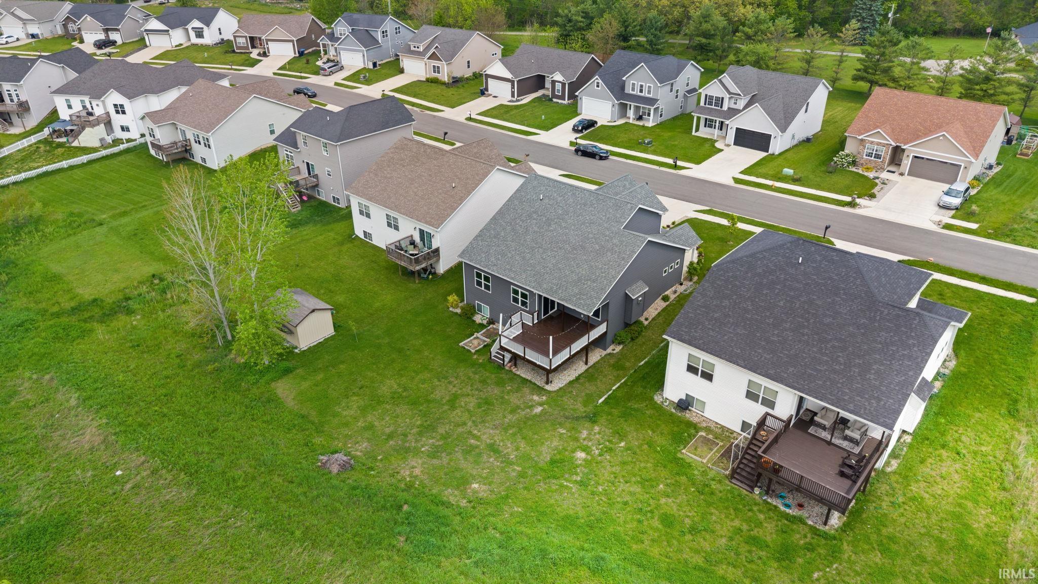Rear elevation with a dark shingle roof and a raised composite deck