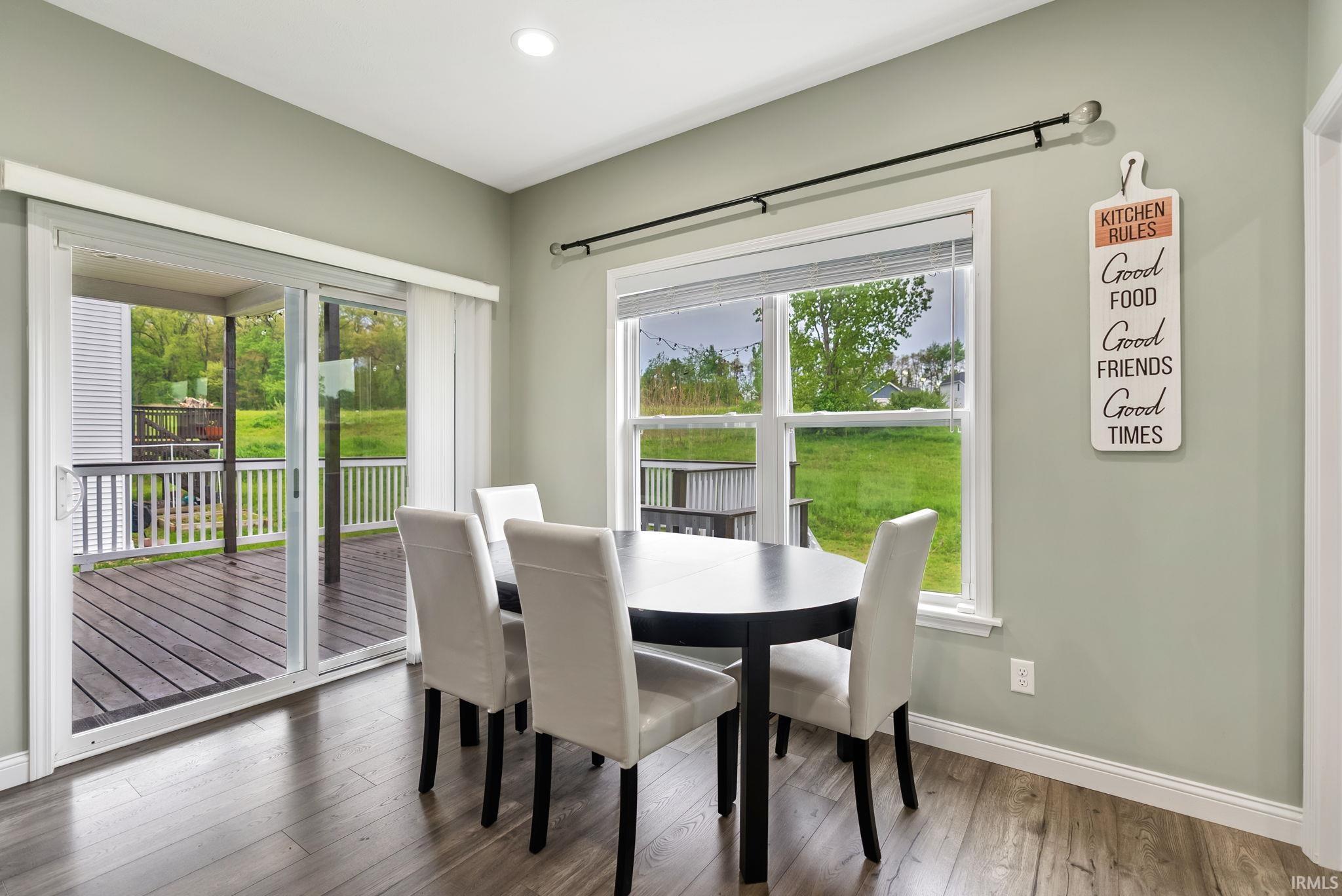 Dining area with wood-finish flooring, recessed lighting, and a large window