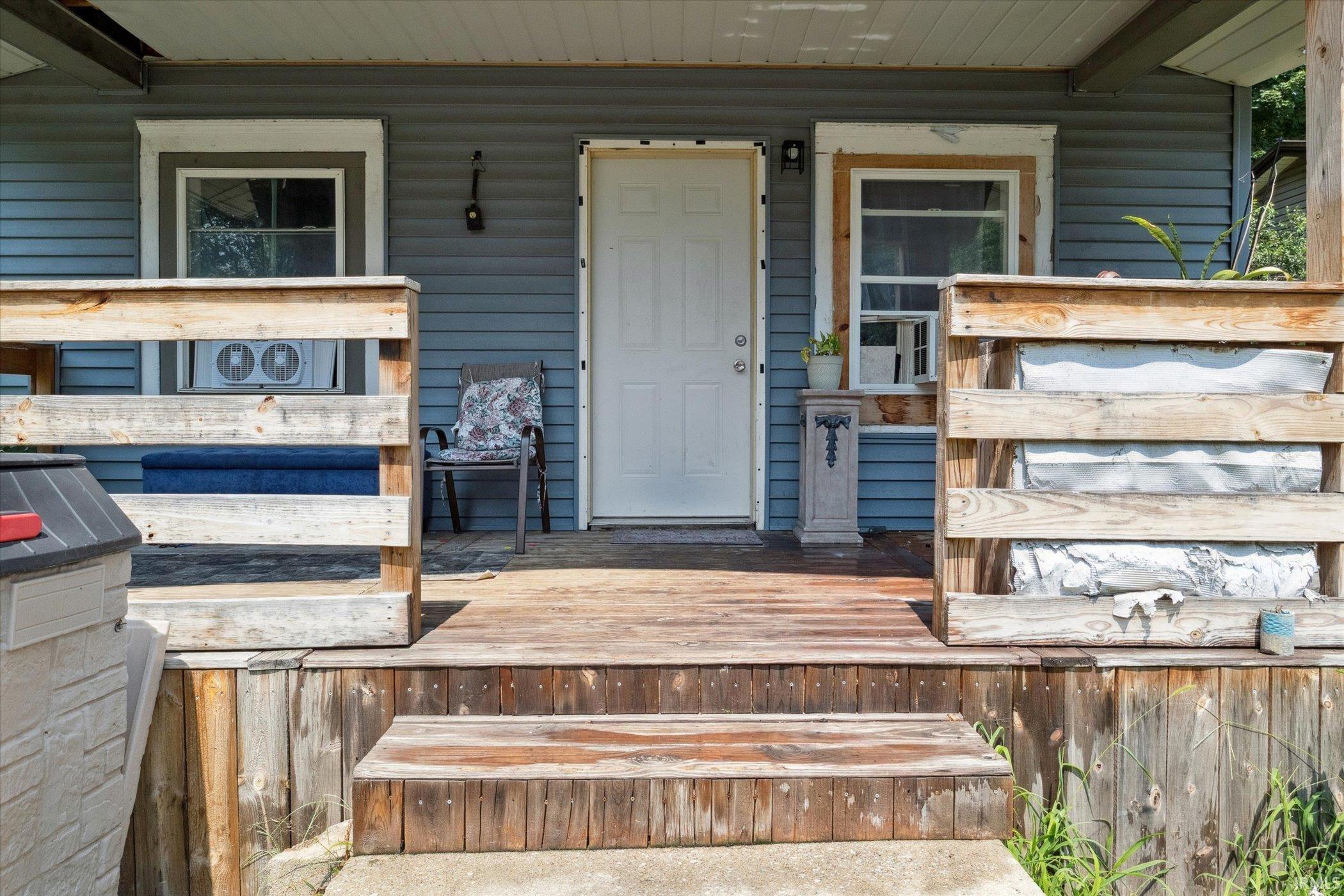 Porch entrance featuring wood-finish decking and steps