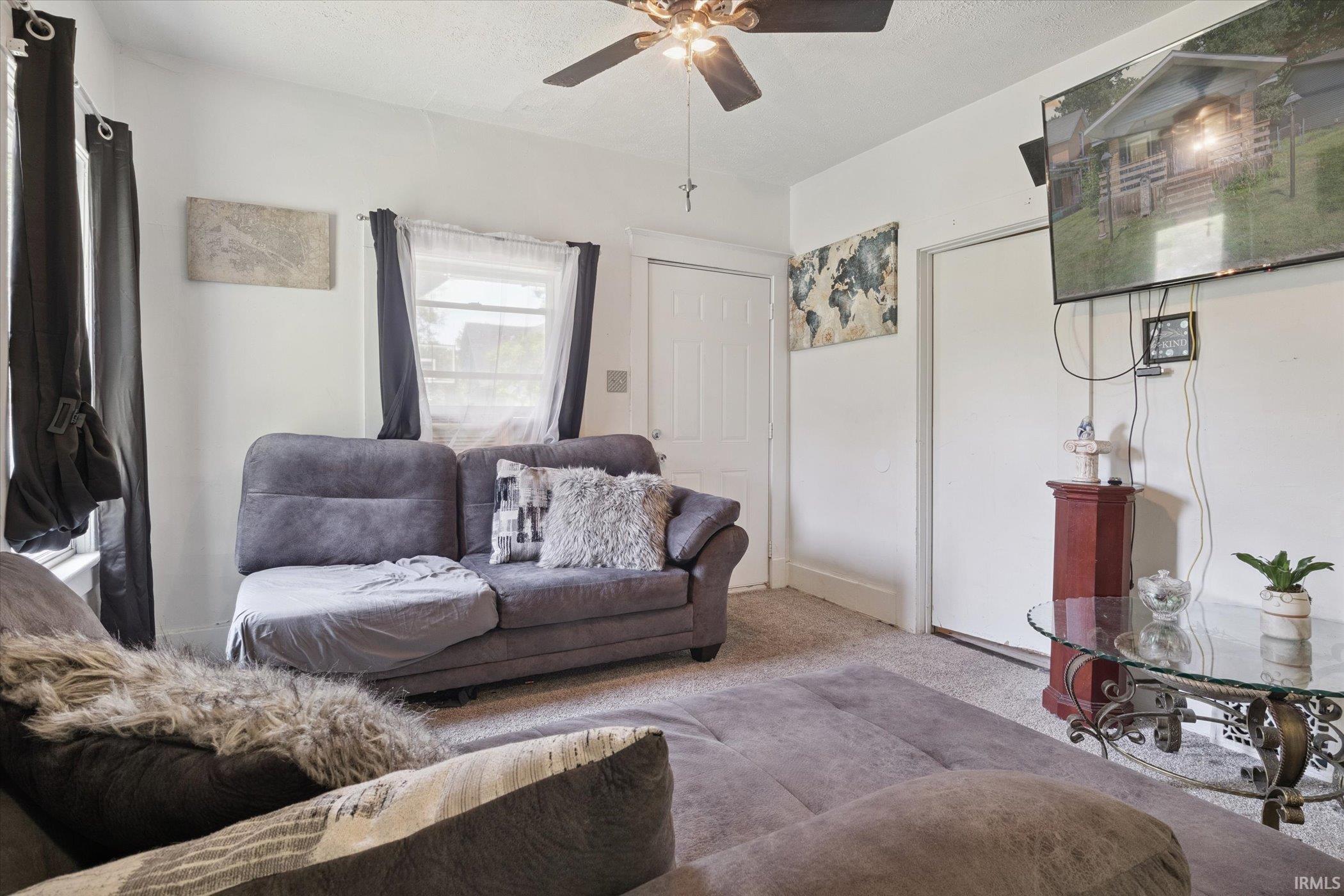 Living area featuring light-colored walls and neutral carpeting