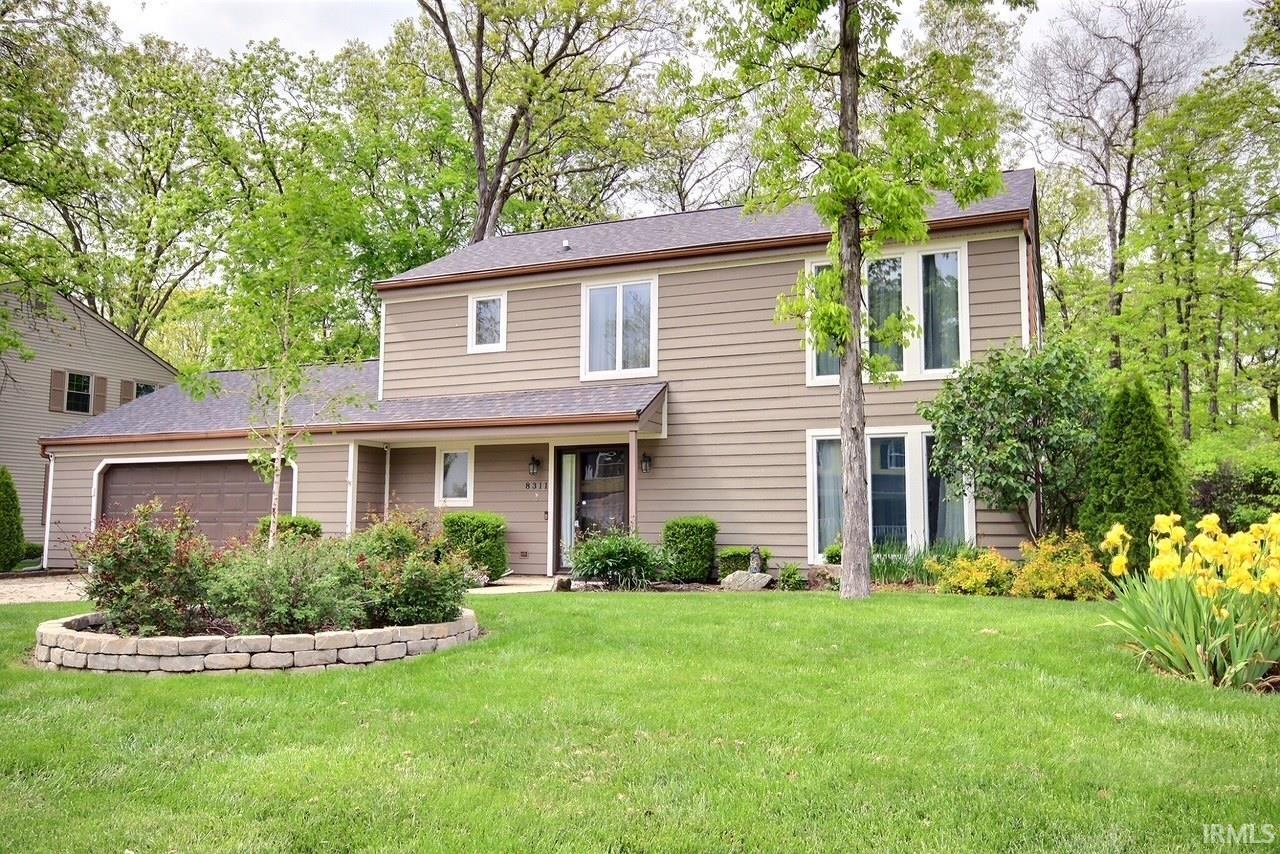 Two-story residence featuring light brown horizontal siding and a two-car garage