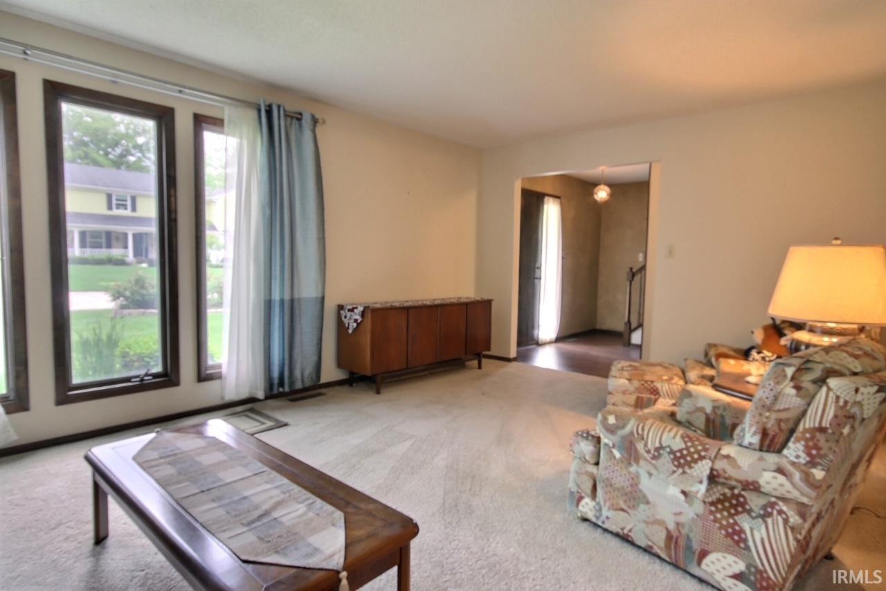 Living room featuring light-toned walls and plush carpeting