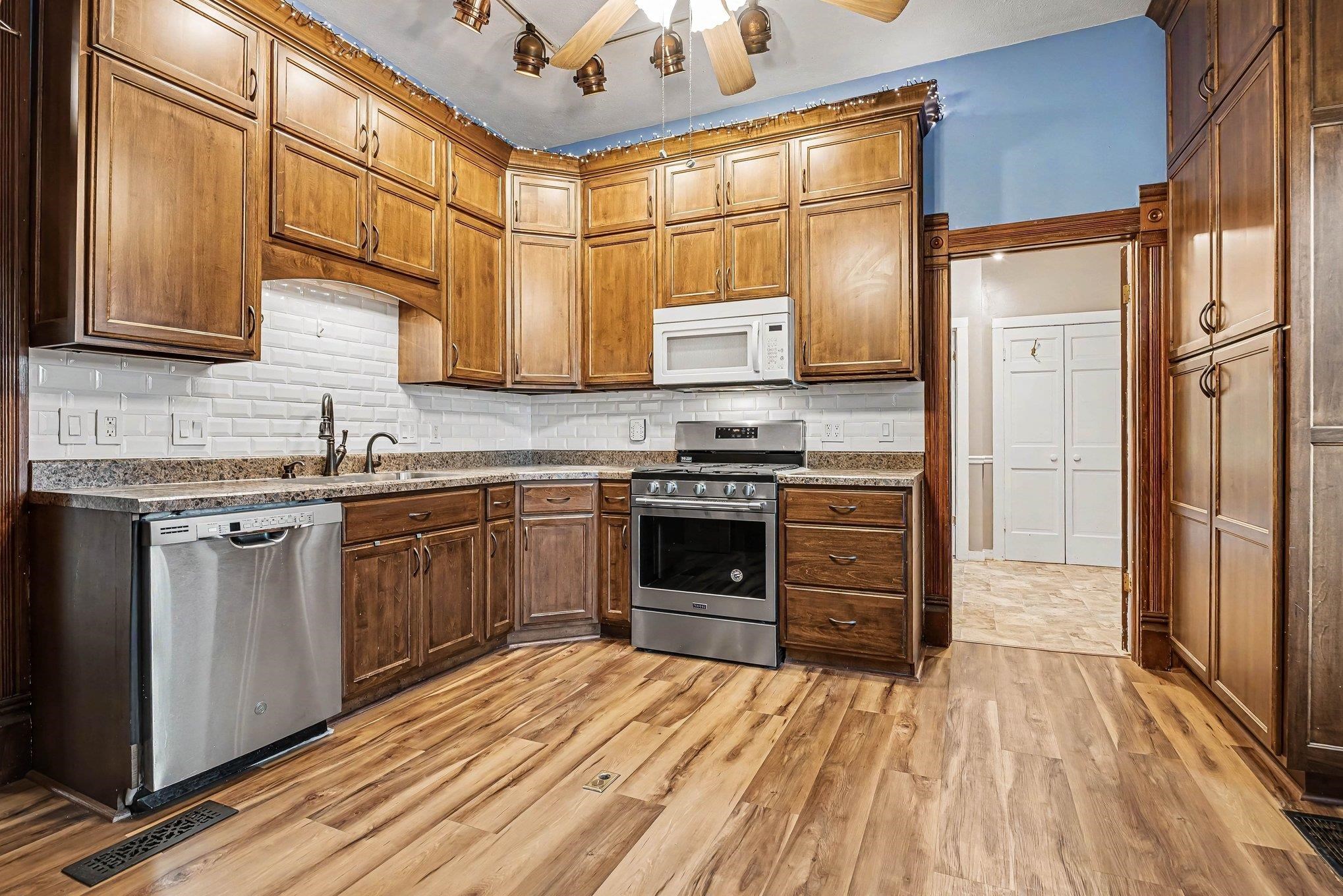 Kitchen featuring wood-finish flooring and extensive cabinetry with matching wood trim