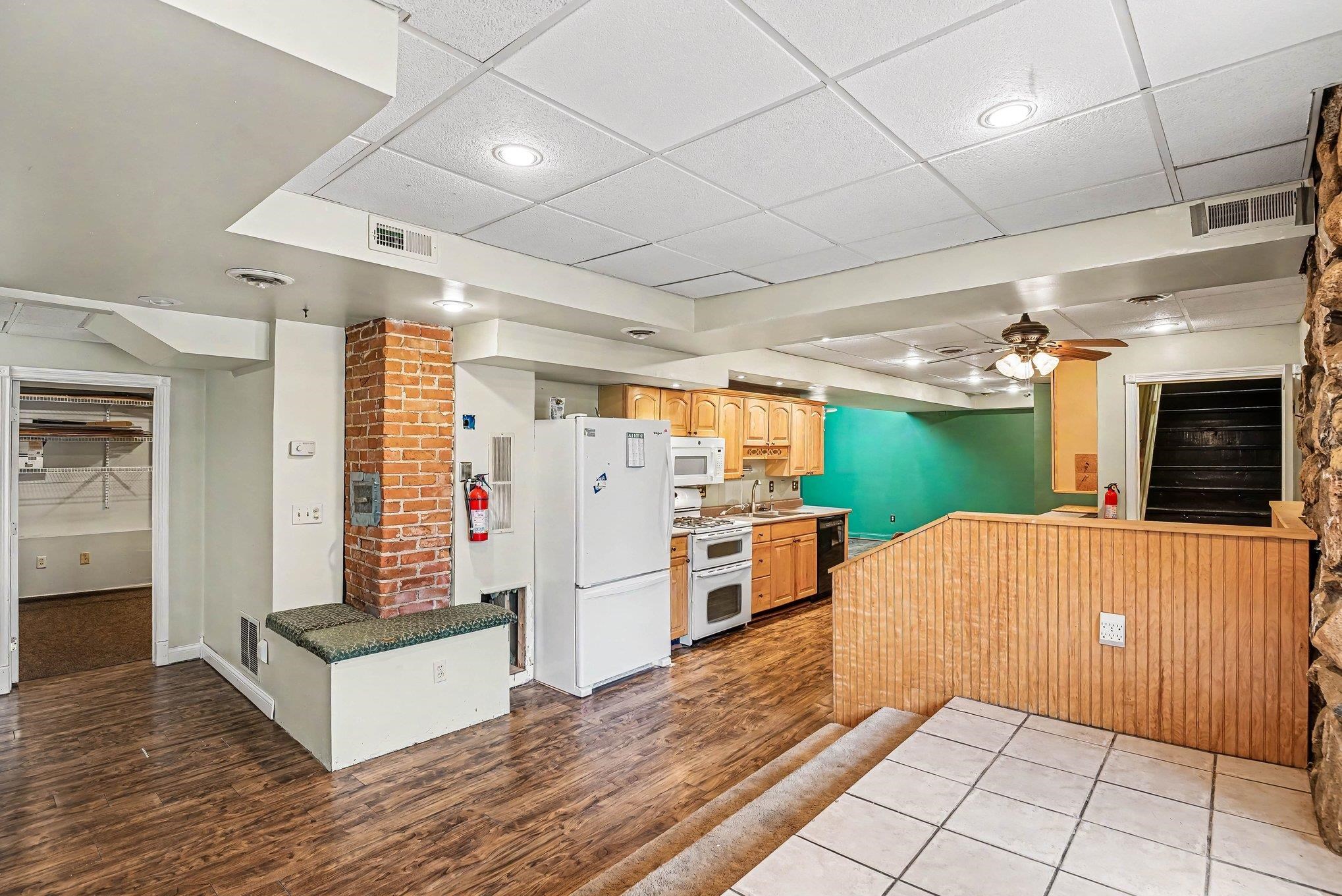 Lower level kitchen area with wood-finish flooring