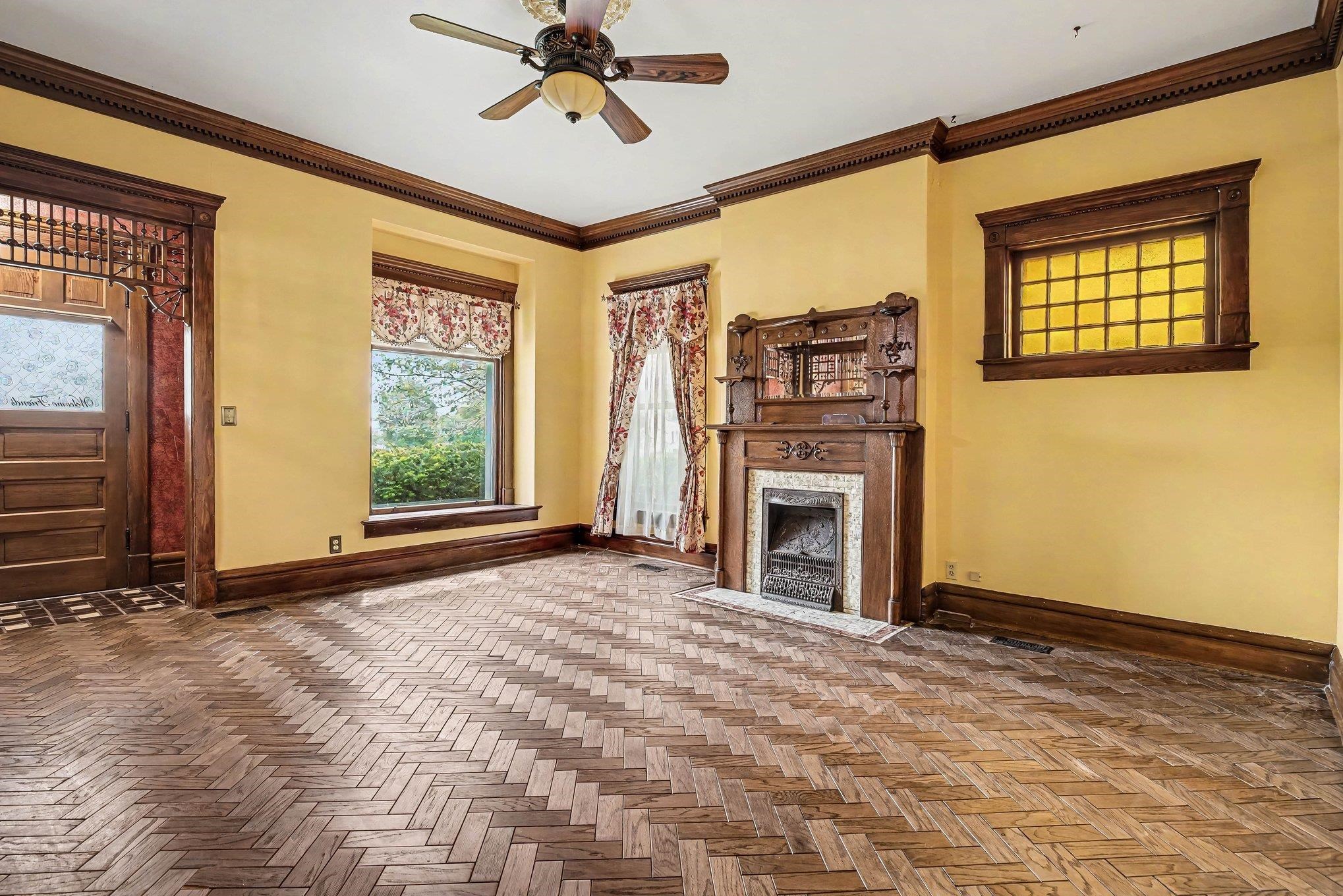 Herringbone wood-finish flooring with a decorative wood mantel fireplace